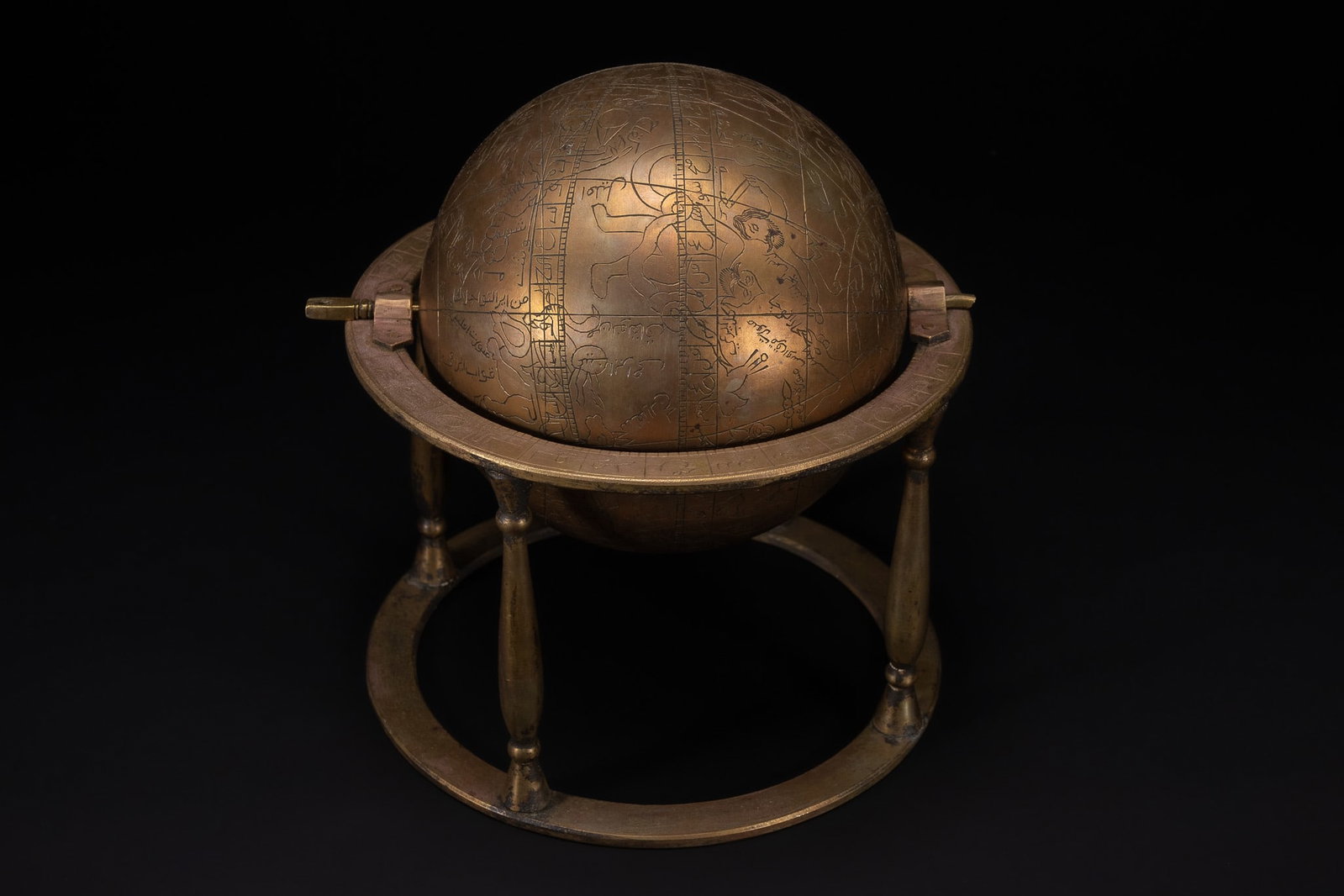 AN ISLAMIC BRASS CELESTIAL GLOBE ON STAND WITH ENGRAVED ZODIAC AND SCRIPT. (1 of 5)