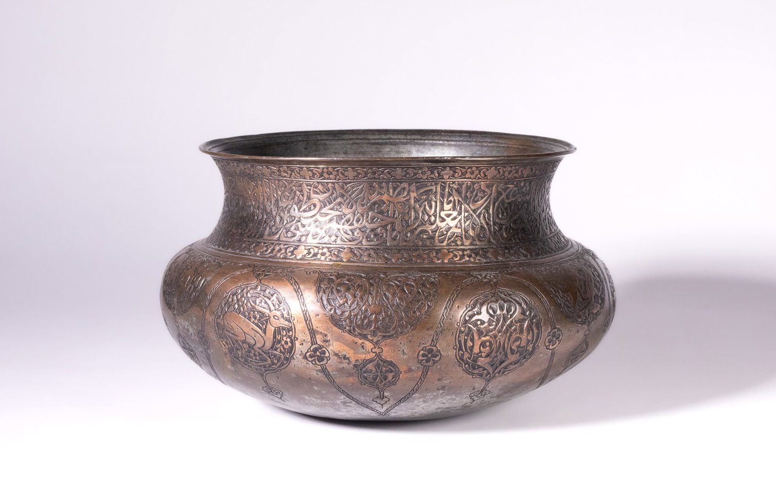 A SAFAVID TINNED COPPER GLOBULAR BOWL, 17TH CENTURY.: A large tinned copper vessel of traditional Persian form, attributed to the Safavid period. The vessel features a globular body tapering to a flat base, a wide constricted neck, and a flared rim. The 