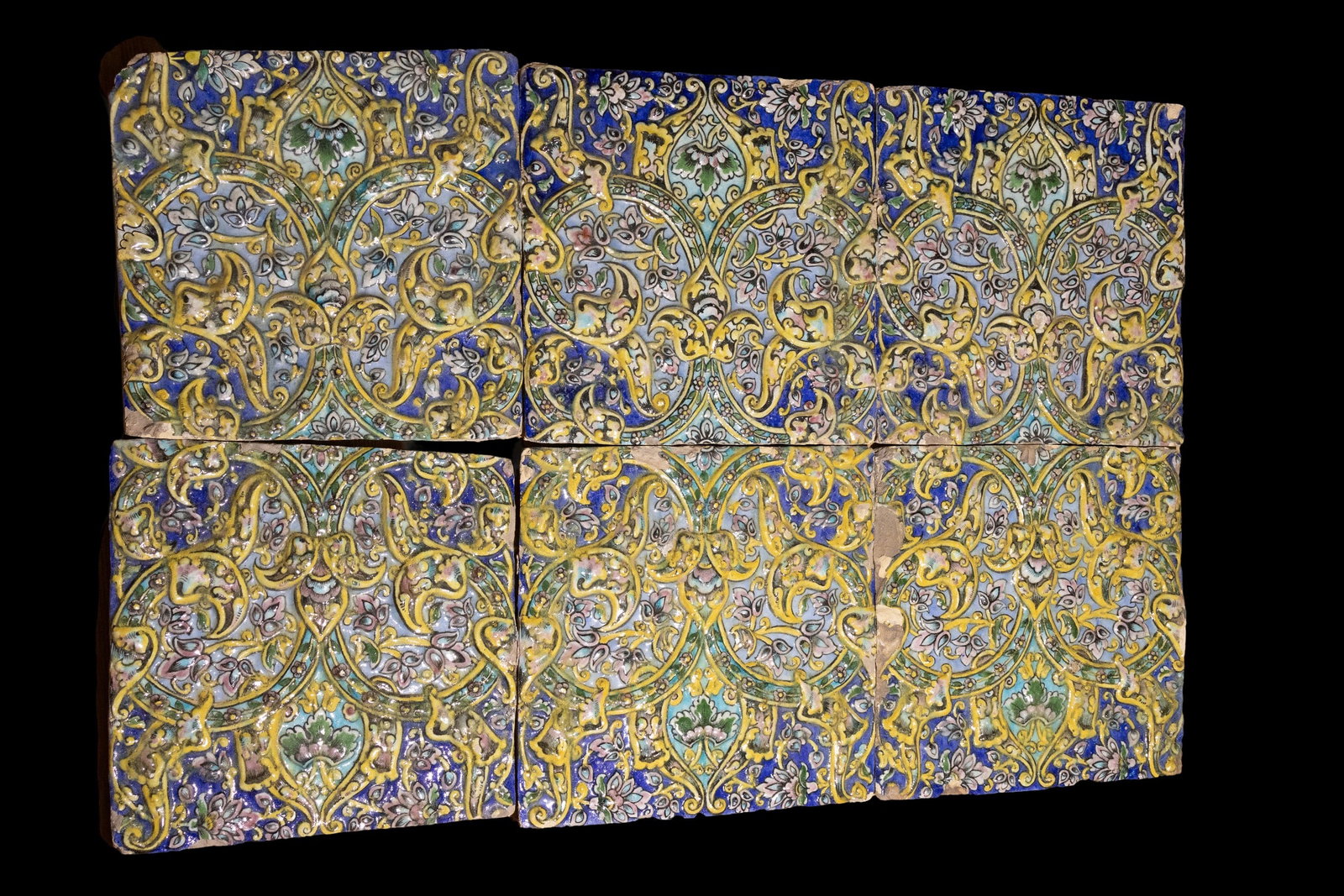 A LOT OF SIX ISLAMIC PERSIAN GLAZED TILES, 19TH CENTURY.: A lot of six Islamic Persian tiles adorned with an elaborate interwoven design in vibrant shades of cobalt blue, yellow, green, and soft pink. The symmetrical pattern features scrolling arabesques, fl