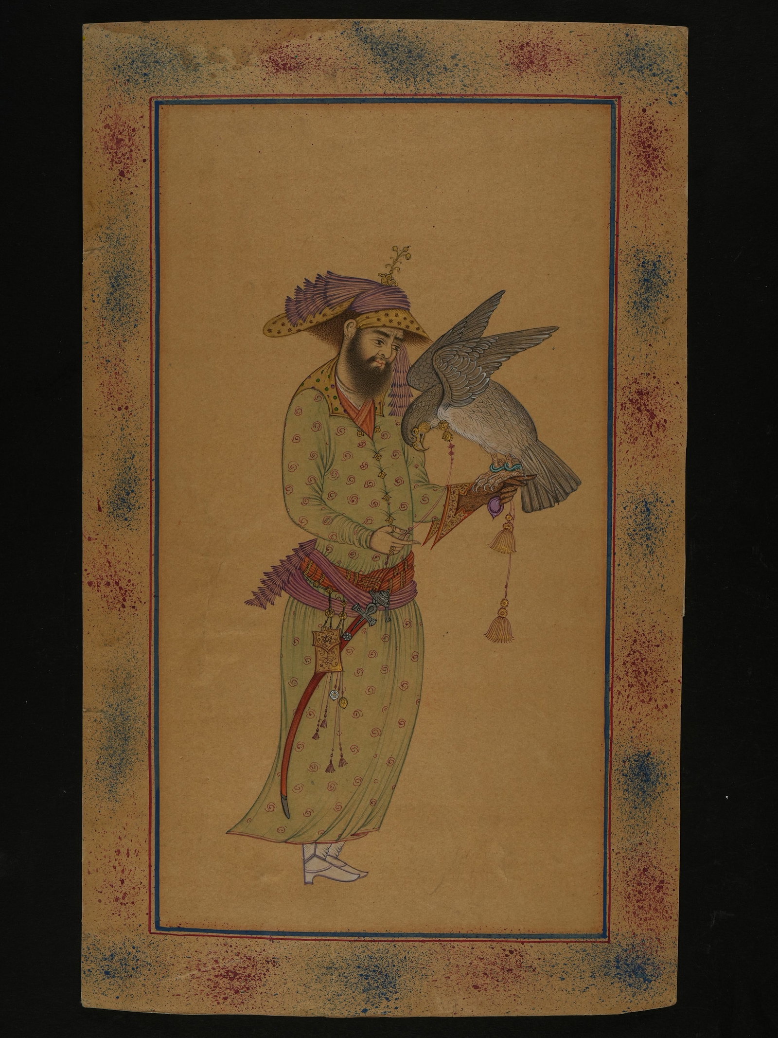 A PERSIAN MINIATURE PAINTING OF A FALCONER WITH HOODED HAWK, 18TH-19TH CENTURY.: Opaque gold pigments and ink on paper, depicting a standing courtly figure holding a hooded hawk perched on his gloved hand. The falconer is shown in profile, dressed in a long patterned robe secured 