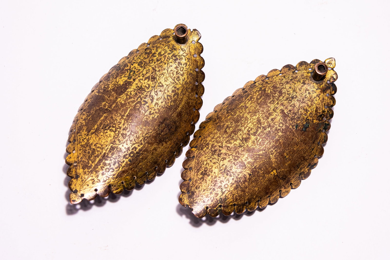 A PAIR OF INDO-PERSIAN GILT COPPER MANDORLA-SHAPED DECORATIVE SCONCE PLATES. (1 of 3)