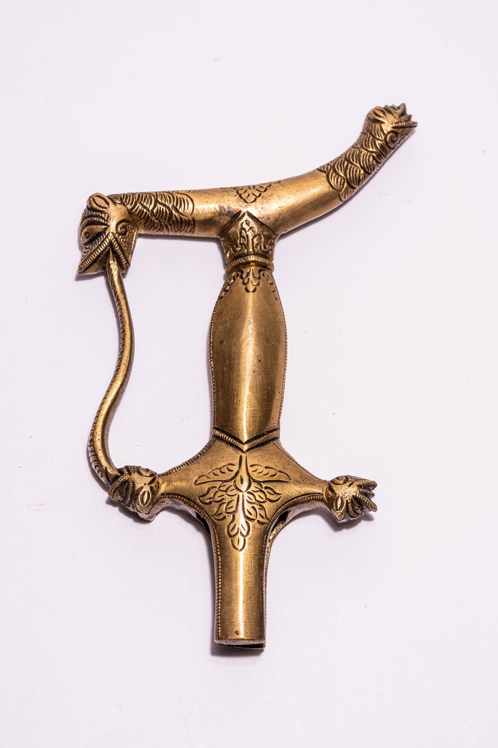 AN INDIAN CAST BRASS SWORD HILT WITH ZOOMORPHIC TERMINALS, 19TH CENTURY. (1 of 2)