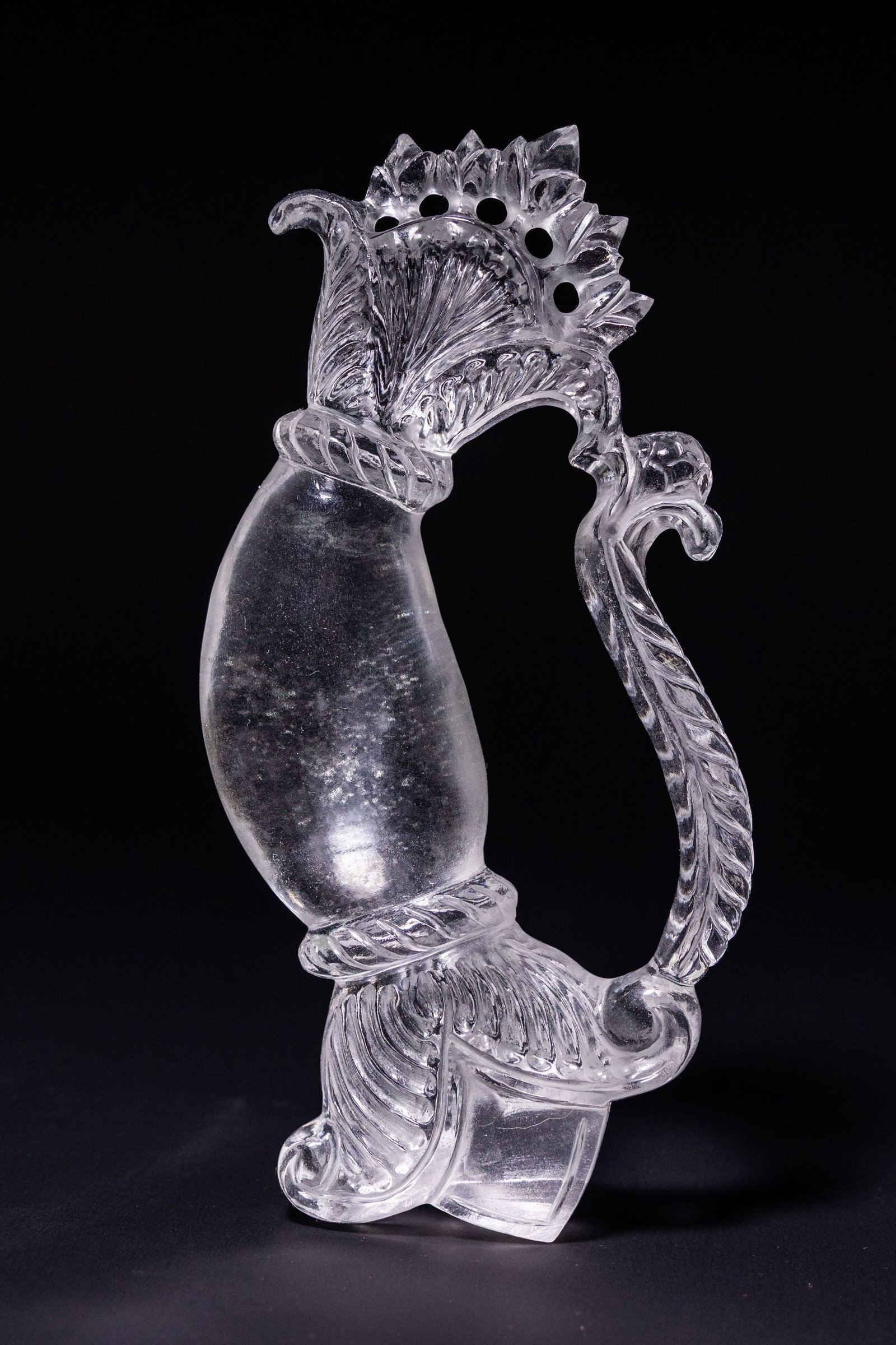 AN INDIAN CARVED ROCK CRYSTAL OR GLASS HILT, 19TH CENTURY OR LATER.: A carved hilt fashioned from a single block of natural rock crystal or glass. The central grip is of ovoid form and polished smooth, flanked by raised collars with a rope-twist pattern. The pommel and