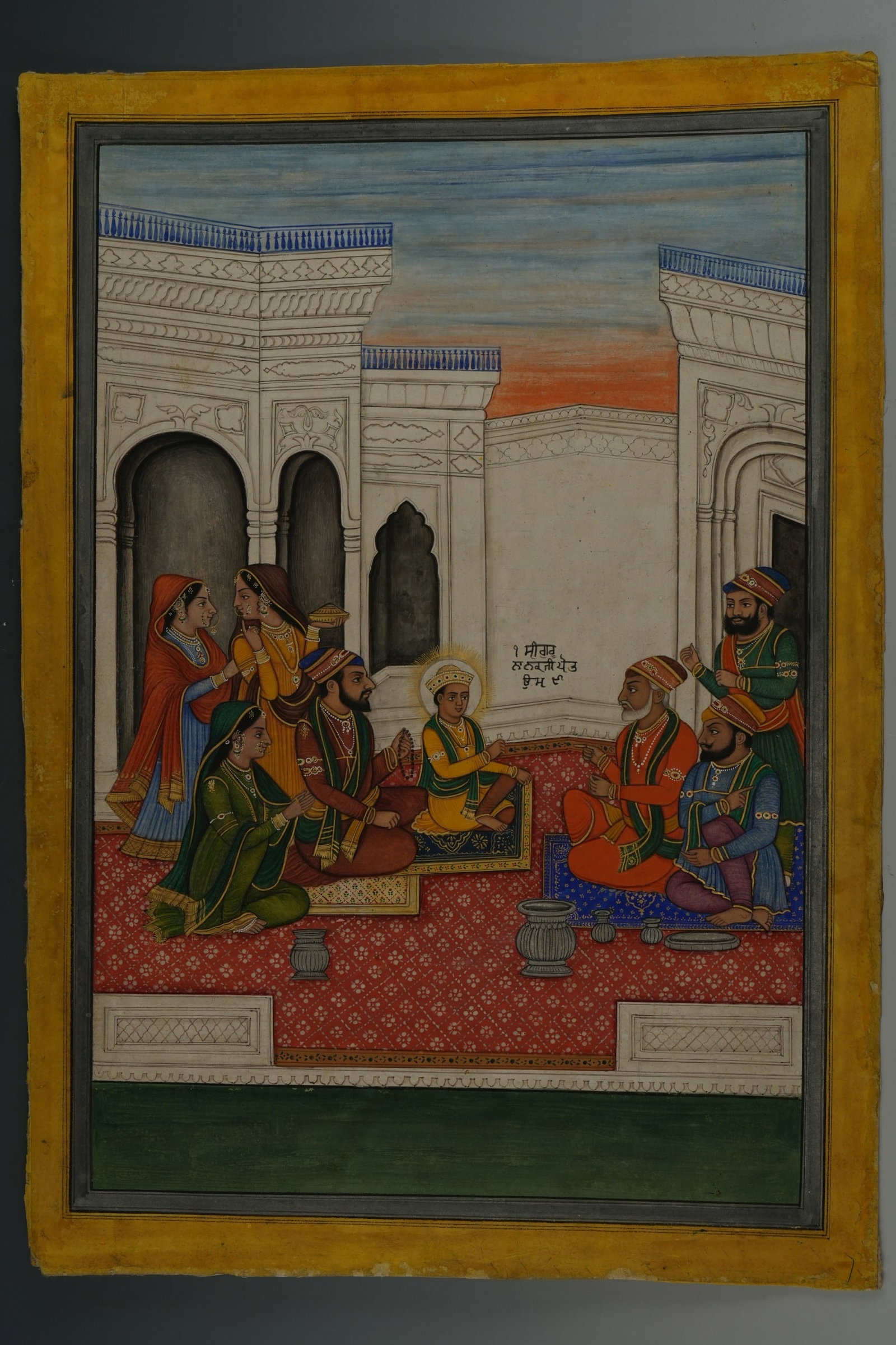AN INDIAN PUNJAB PAINTING DEPICTING 'SRI GURU NANAK JI AT AGE SIX', 19TH CENTURY.: This Indian miniature painting, executed in gouache on paper, depicts a narrative scene from a Janamsakhi (biographical account) of Guru Nanak. The central figure of a young Guru Nanak is shown with a