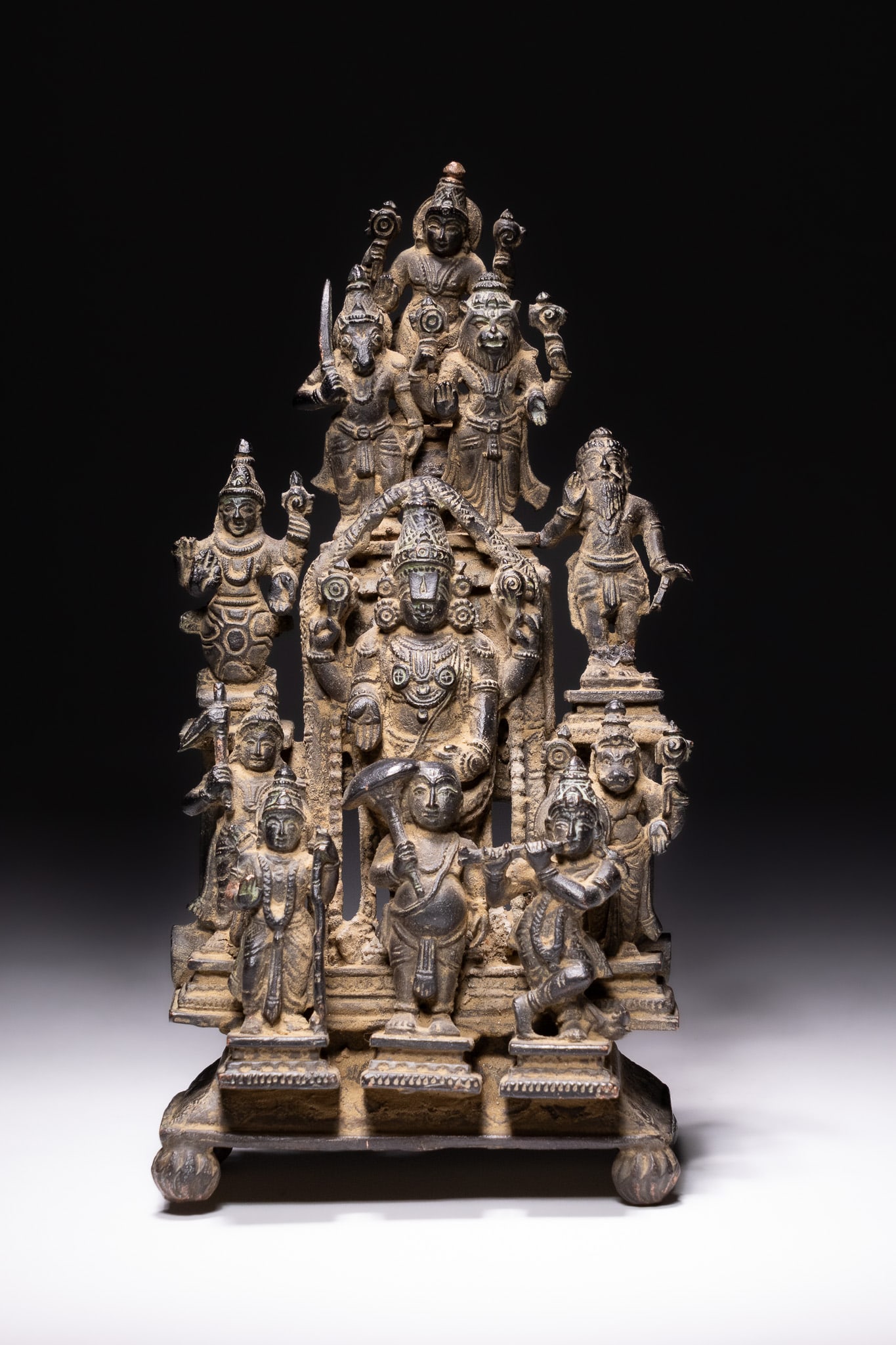 A SOUTH INDIAN COPPER ALLOY SHRINE OF VISHNU AND THE DASHAVATARA, 18TH-19TH CENTURY.: This complex, tiered religious altarpiece or shrine is cast from a copper alloy and depicts Lord Vishnu at the centre, surrounded by his ten principal incarnations known as the Dashavatara. The centra