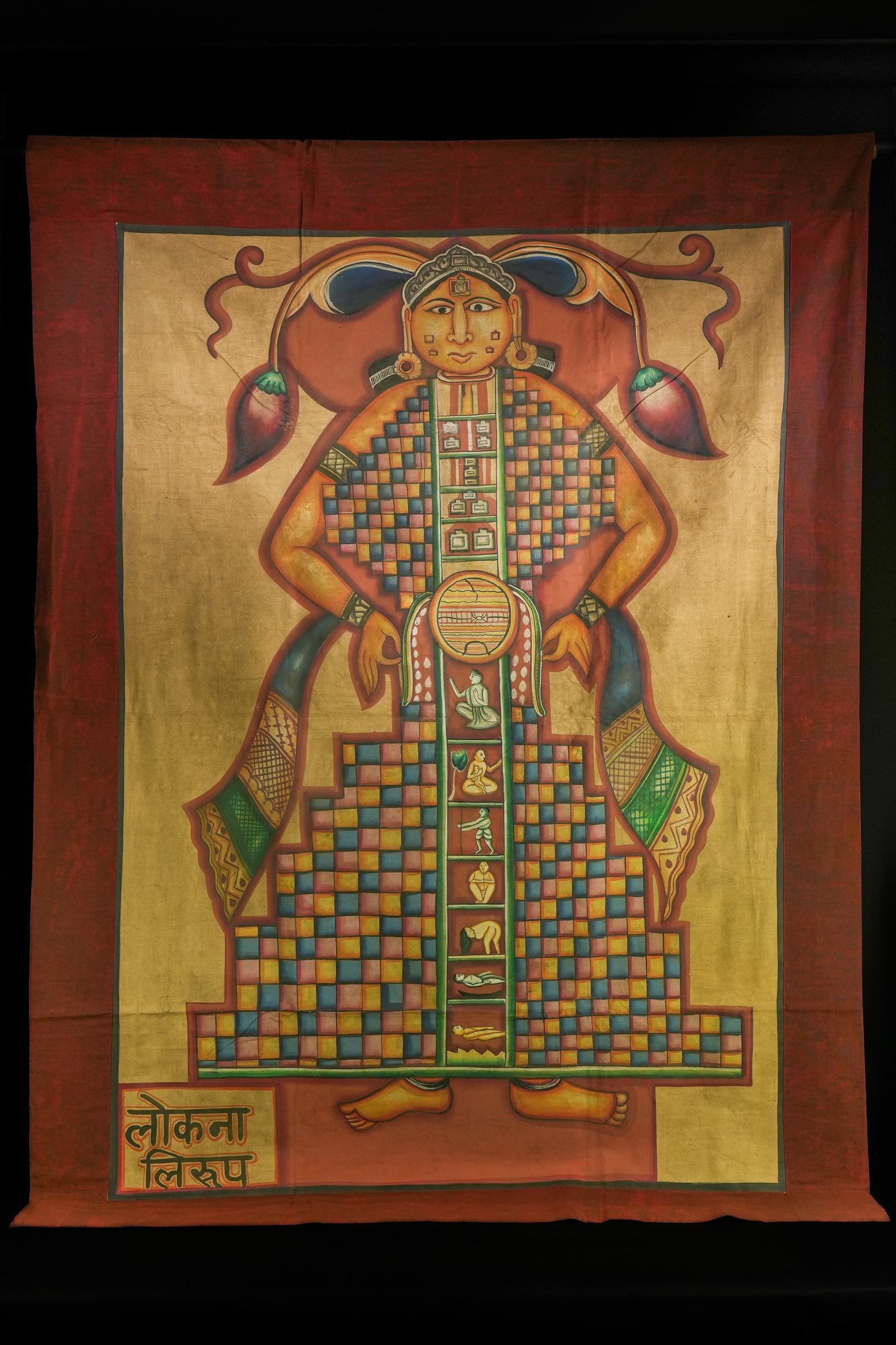 AN INDIAN JAIN COSMIC MAN (LOKAPURUSHA) TANTRIC TEXTILE, 20TH CENTURY.: A Jain tantric painting depicting a frontal standing deity figure rendered against a warm golden ground and framed within a deep red border. The figure is shown with a broad face, arched brows, elonga