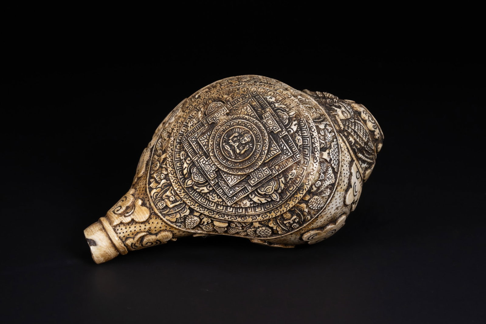 A TIBETAN CARVED CONCH SHELL WITH INTRICATE BUDDHIST MOTIFS. (1 of 6)