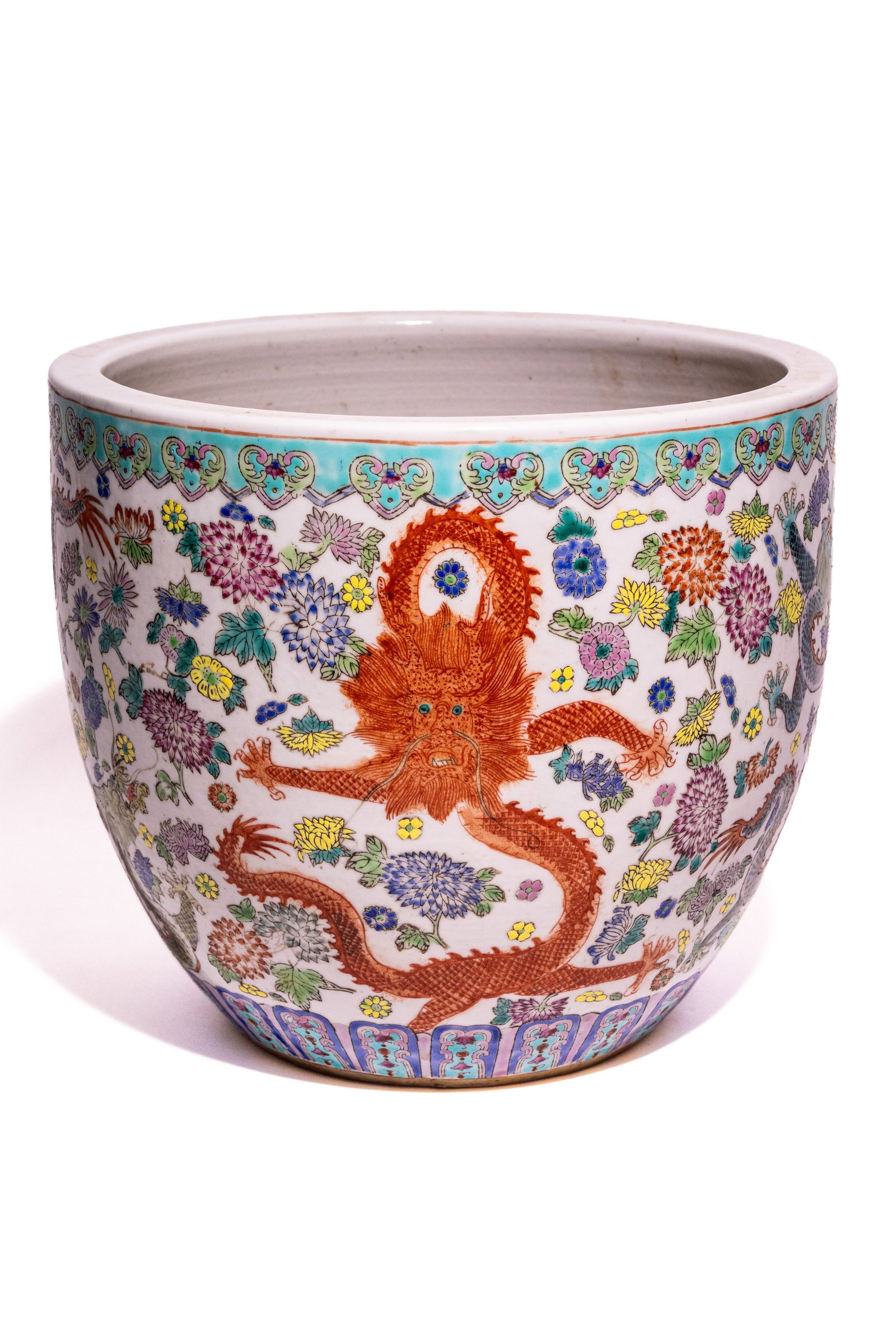 A LARGE CHINESE FAMILLE ROSE MILLE-FLEUR AND DRAGON JARDINI??RE.: A large Chinese porcelain jardinière or fish bowl decorated in the famille rose palette. The exterior surface is densely enamelled with a mille-fleur or hundred flowers ground, featuring a vari