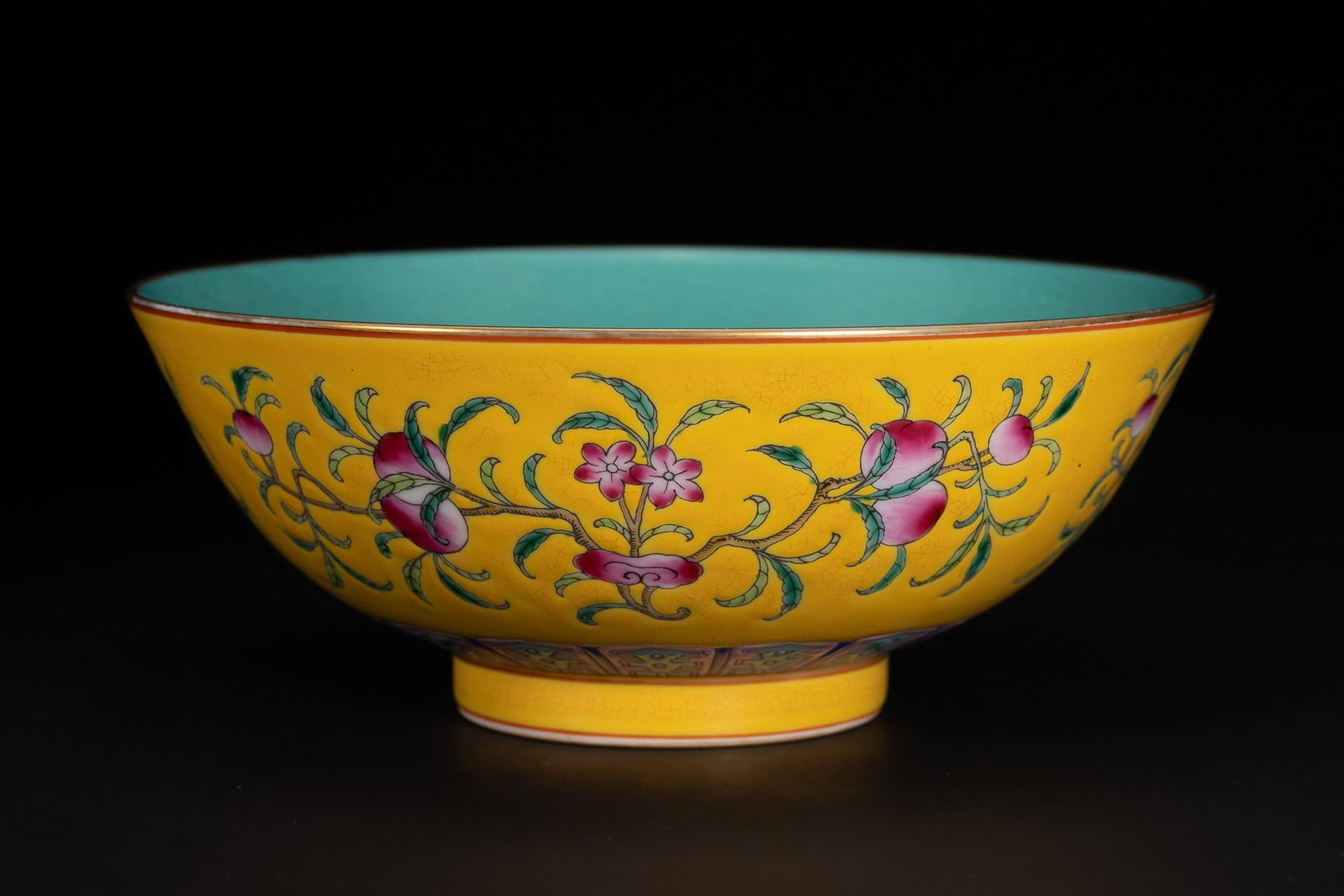 A CHINESE YELLOW-GROUND FAMILLE ROSE PORCELAIN 'PEACH AND CRANE' BOWL, QIANLONG MARK. (1 of 3)