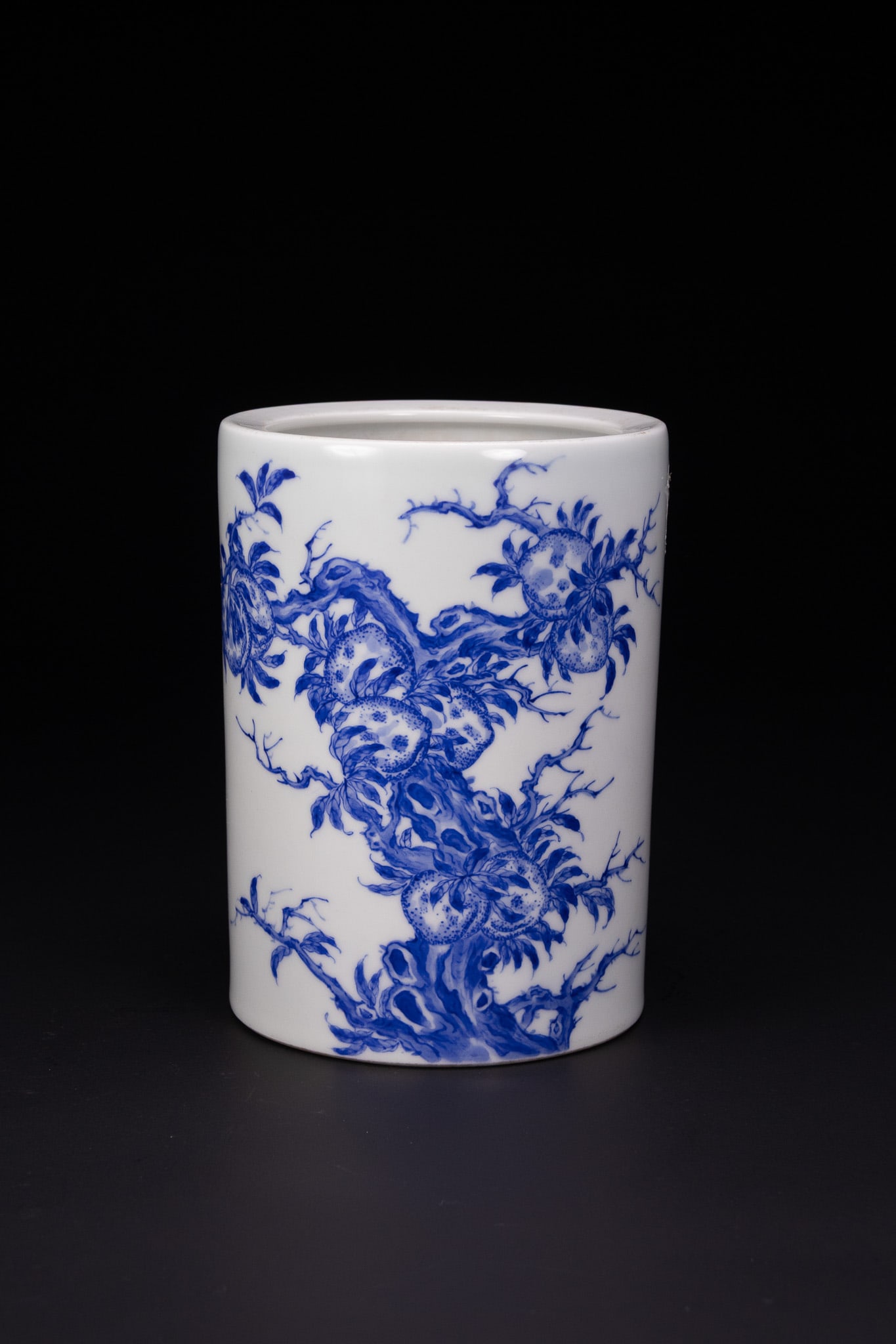 A CHINESE BLUE AND WHITE PORCELAIN PEACH TREE BRUSH POT BITONG, WANG BU MARK.: This Chinese blue and white porcelain brush pot is attributed to the artist Wang Bu (1898-1968). Of cylindrical form with a flat base and a slightly recessed centre, the vessel dates to the 20th centu