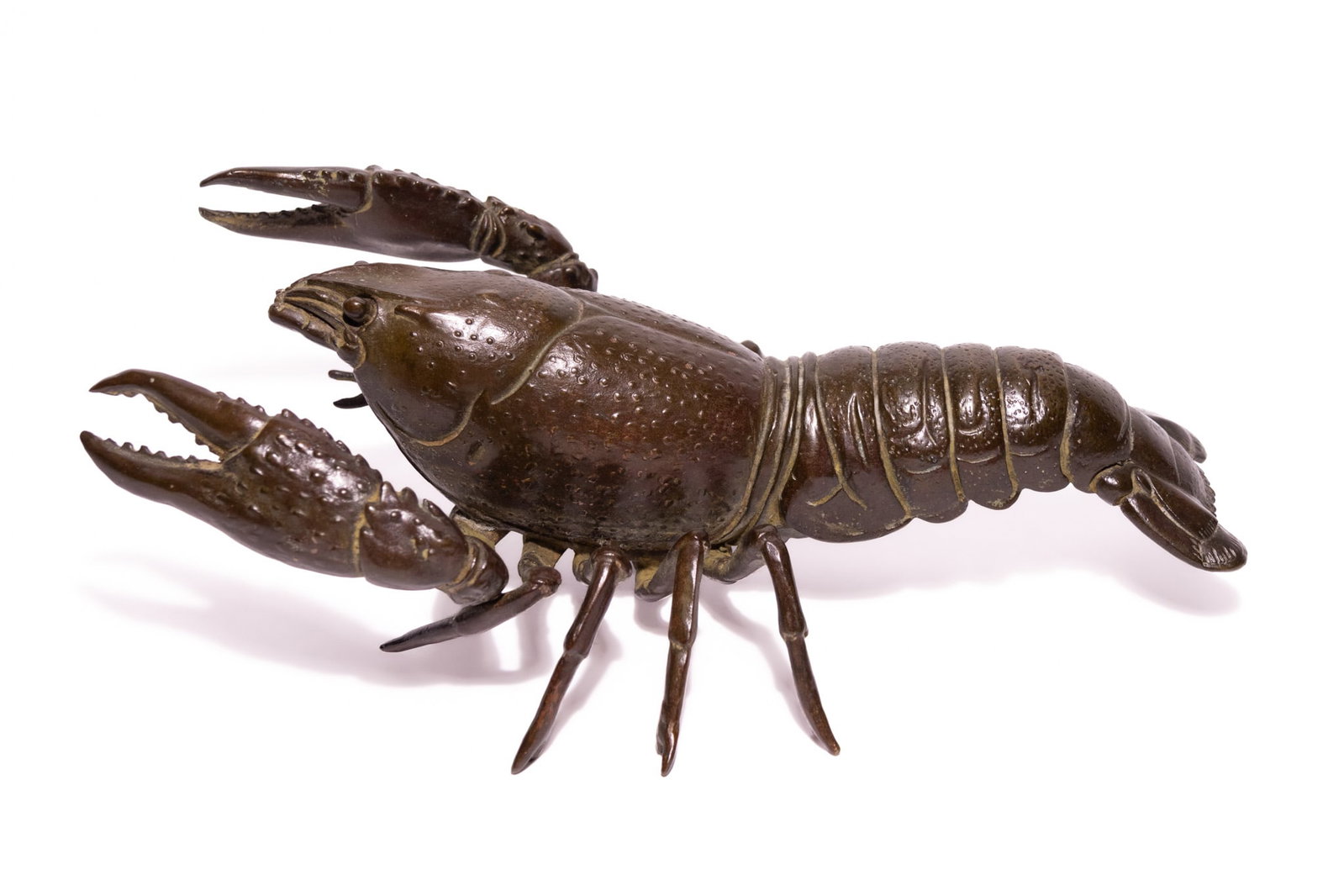 A LARGE JAPANESE BRONZE JIZAI OKIMONO OF A CRAYFISH.: A Japanese patinated bronze jizai okimono (articulated sculpture) of a freshwater crayfish. The figure is constructed from multiple cast bronze sections, including an articulated segmented tail, legs,