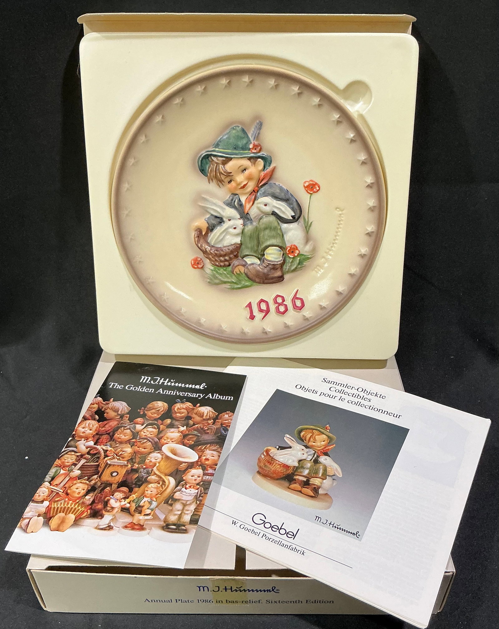 1986 M.I. Hummel Annual Plate "School Boy" by Goebel (Hum 282): Boy with rabbits and basket; raised '1986'; original box and 'Golden Anniversary Album' booklet.