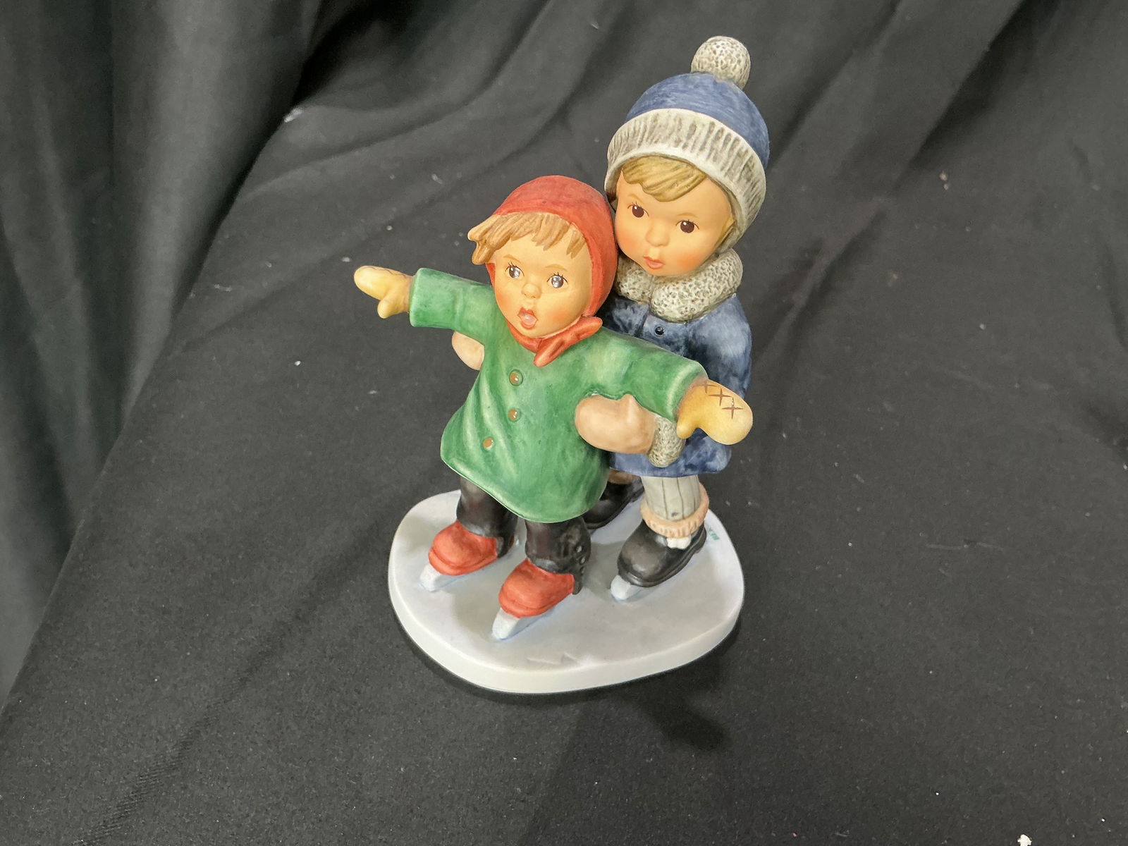 Goebel Berta Hummel Skating Lesson Figurine (BH 240): Charming Goebel Berta Hummel figurine titled 'Skating Lesson' (BH 240), dated 2003. Features two children ice skating, with one guiding the other across a snowy base. Hand-painted and marked on the un