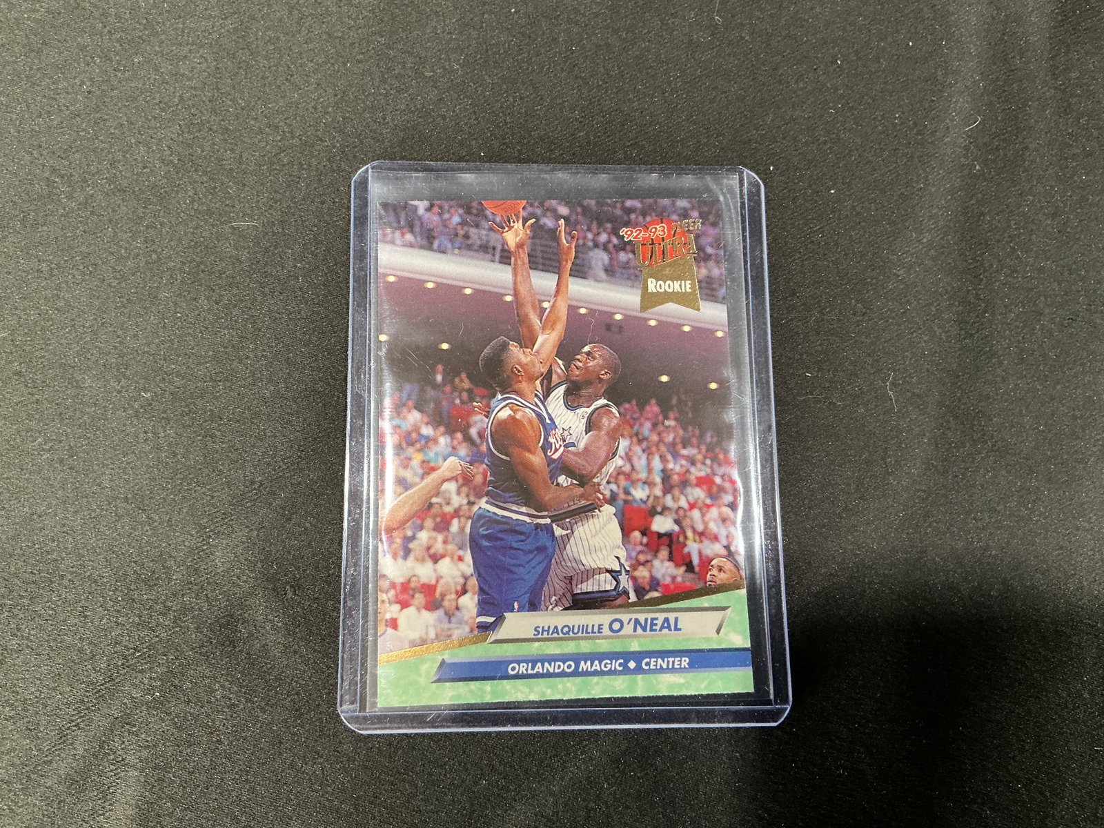 1992-93 Fleer Ultra Shaquille O’Neal Rookie NBA trading Card: 1992-93 Fleer Ultra rookie card featuring Shaquille O’Neal in action during his rookie season with the Orlando Magic. Card shows classic Fleer Ultra design with action photography. Encapsulated in a