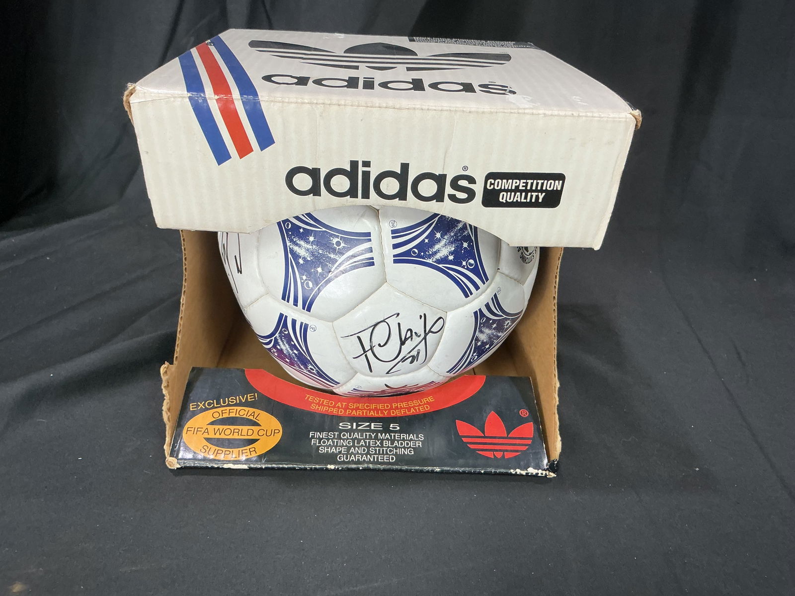 Adidas FIFA World Cup Official type Game Ball with Signatures and Original Display Box: Adidas official Size 5 FIFA World Cup game ball presented in original display box. Ball features 11 visible signatures in black marker of the full team. Box shows wear consistent with age and storage.