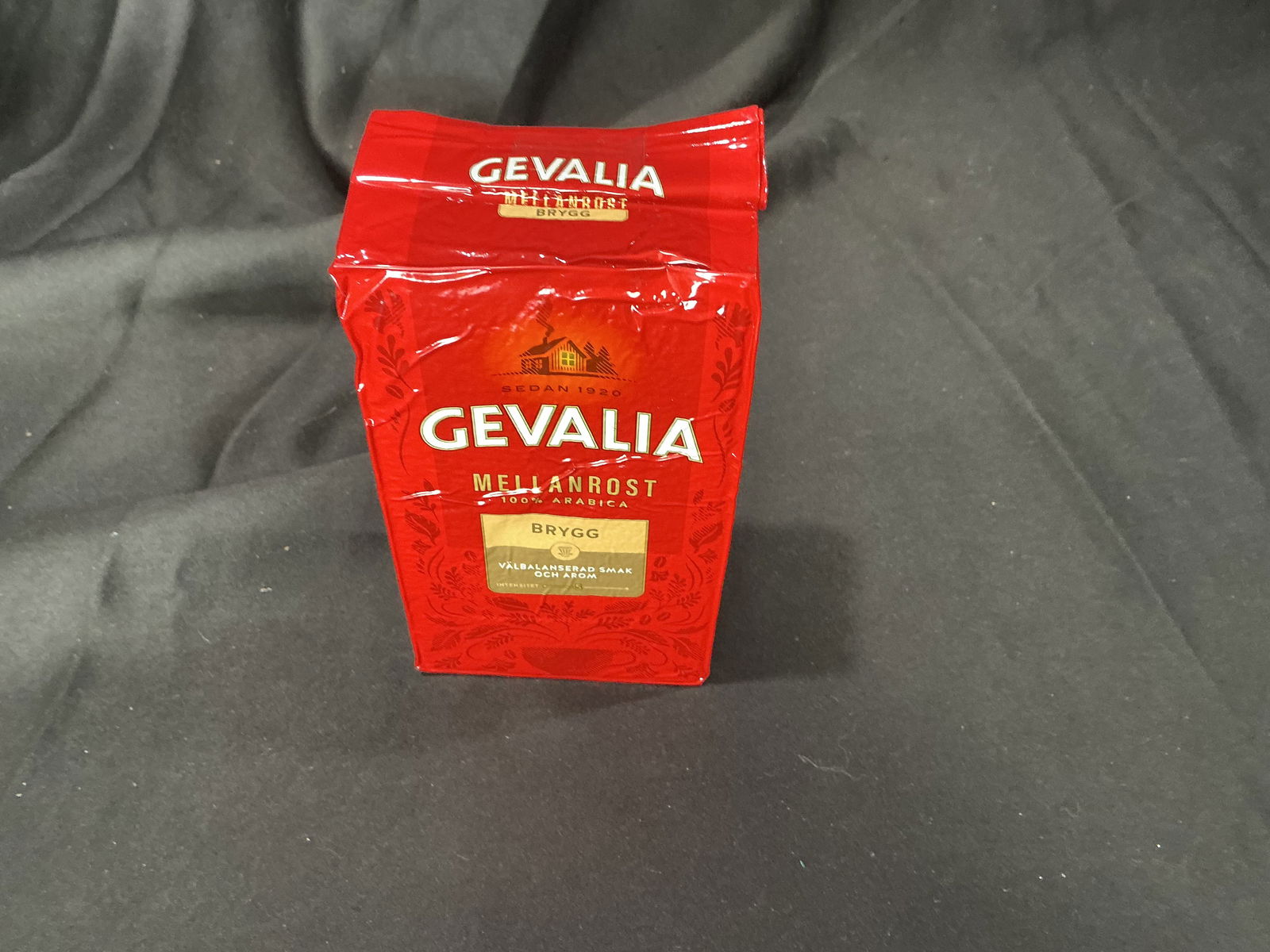 Gevalia Mellanrost coffee retail display package: Empty Gevalia Mellanrost coffee retail package, 100% Arabica, originally containing 450g. Printed Swedish-language packaging in red with branding and product information on all sides. Likely used as a