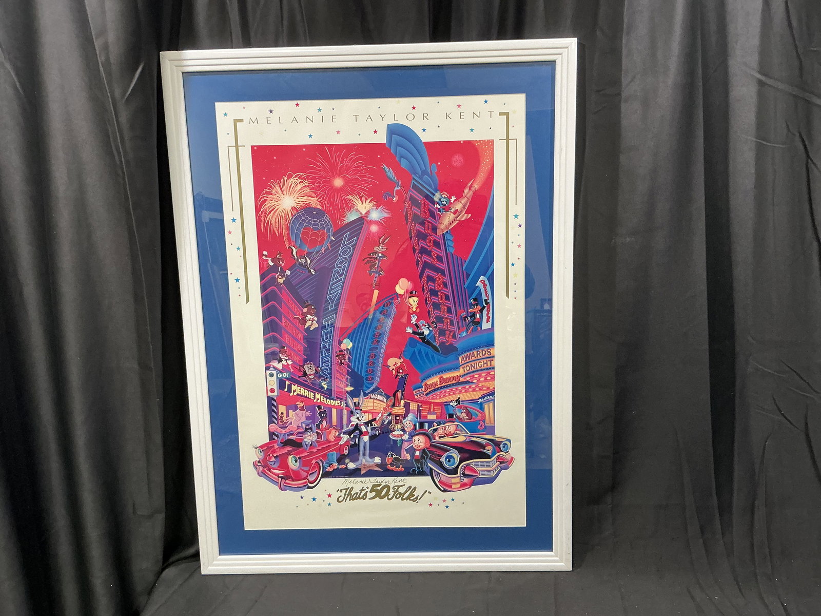 Melanie Taylor Kent 'That's 50 Folks!' Limited Edition Print: Framed limited edition color print titled 'That's 50 Folks!' by Melanie Taylor Kent, featuring iconic Warner Bros. characters in a celebratory cityscape. Signed by the artist in pencil and marked PP 1