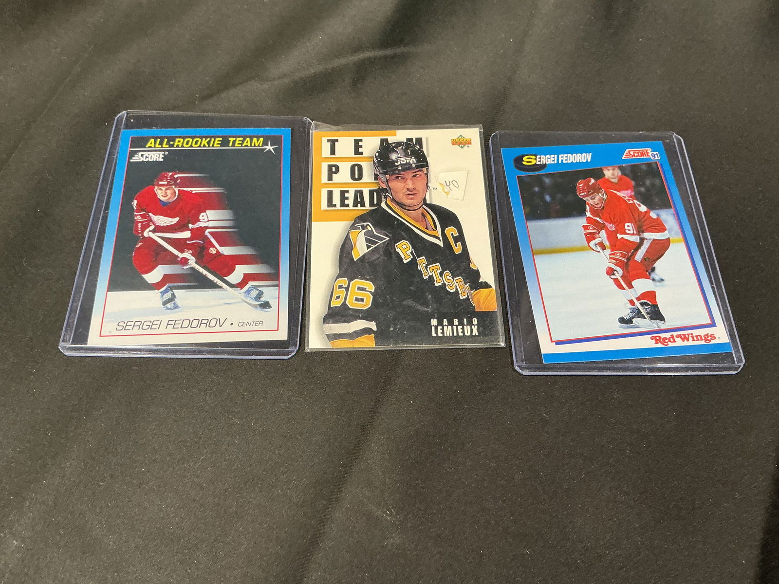 Three hockey trading cards: Sergei Fedorov & Mario Lemieux: Three-card hockey trading card lot featuring Sergei Fedorov and Mario Lemieux. Includes two Sergei Fedorov cards and one Mario Lemieux card. Cards are in protective holders. Please review photos for