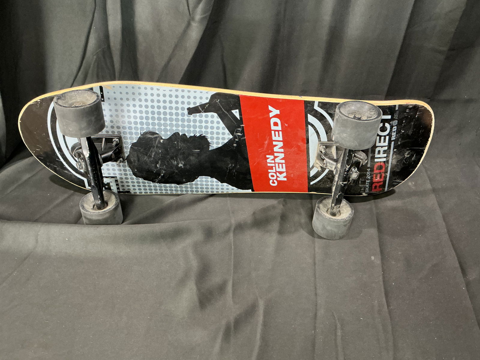 Vintage Colin Kennedy Red Ire skateboard complete: Features a Colin Kennedy Red Ire deck with graphic underside, black trucks, and black wheels. The deck shows typical skate wear from use, with grip tape applied to the top and original hardware presen