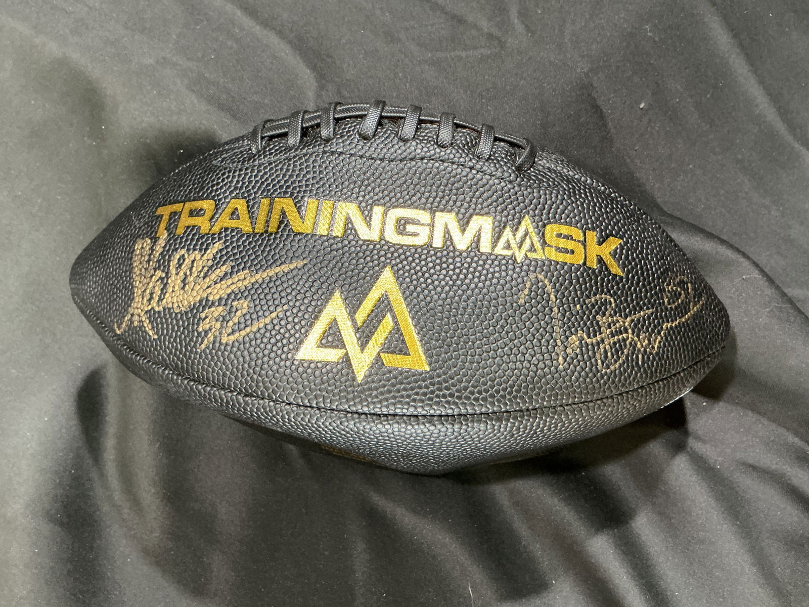 TrainingMask Black Football; two Gold Signs, Markus Allen and Tim Brown Limited Promotional Edition: Unique 'TrainingMask' promotional football finished in sleek black leatherette with gold embossed lettering and matching dual gold autographs from Markus Allen and Tim Brown. This collectible piece wa