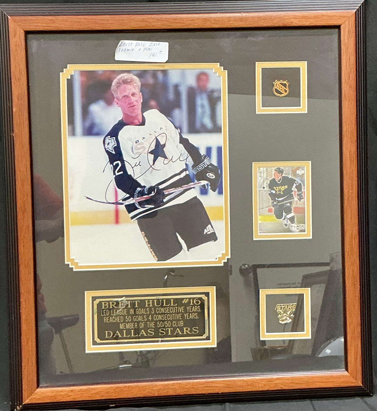Brett Hull Signed Dallas Stars Framed Display Photo Pins Card: Framed pro Hockey player Brett Hull Dallas Stars memorabilia display featuring a large signed color photograph of Hull in Stars uniform. The presentation also includes NHL and Dallas Stars pins and a