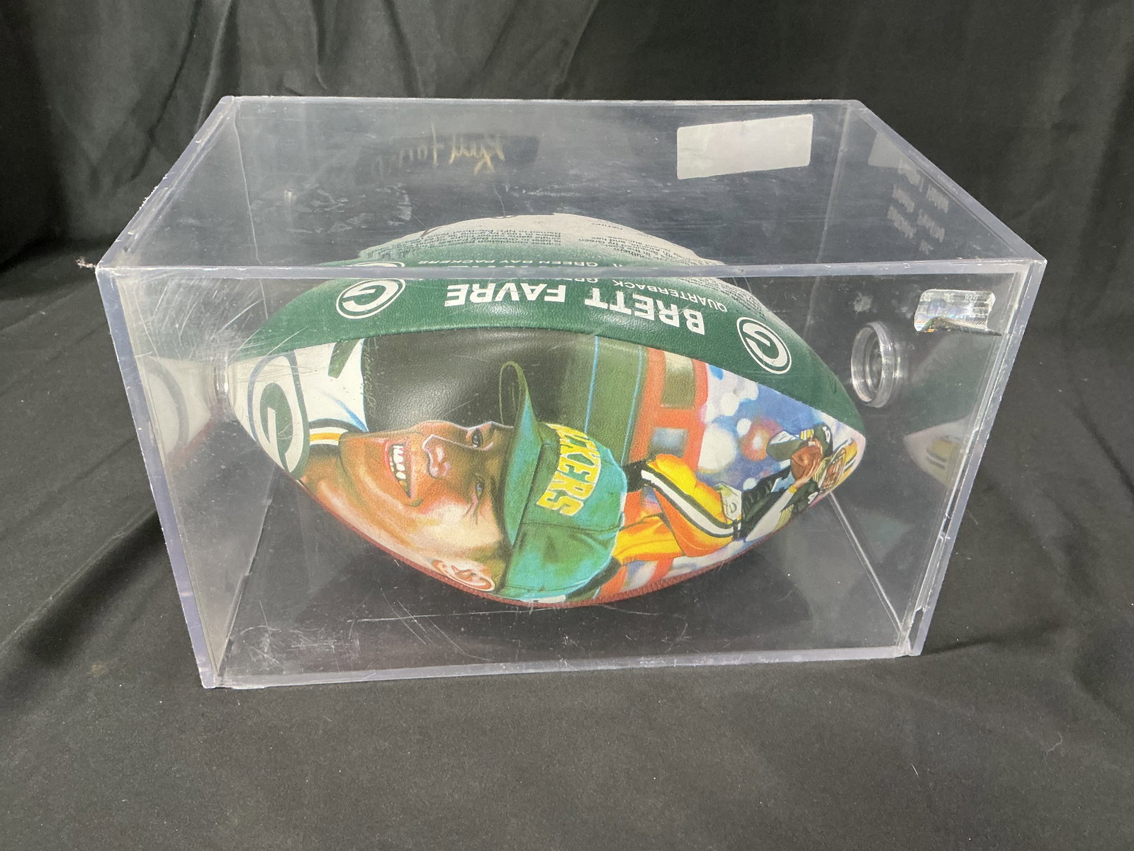 Autographed Brett Favre Wilson NFL Football with Display Case: Wilson NFL official size composite football personally signed by Brett Favre. Signature appears in gold marker. Display case included. Signature has not been authenticated and is sold as-is.