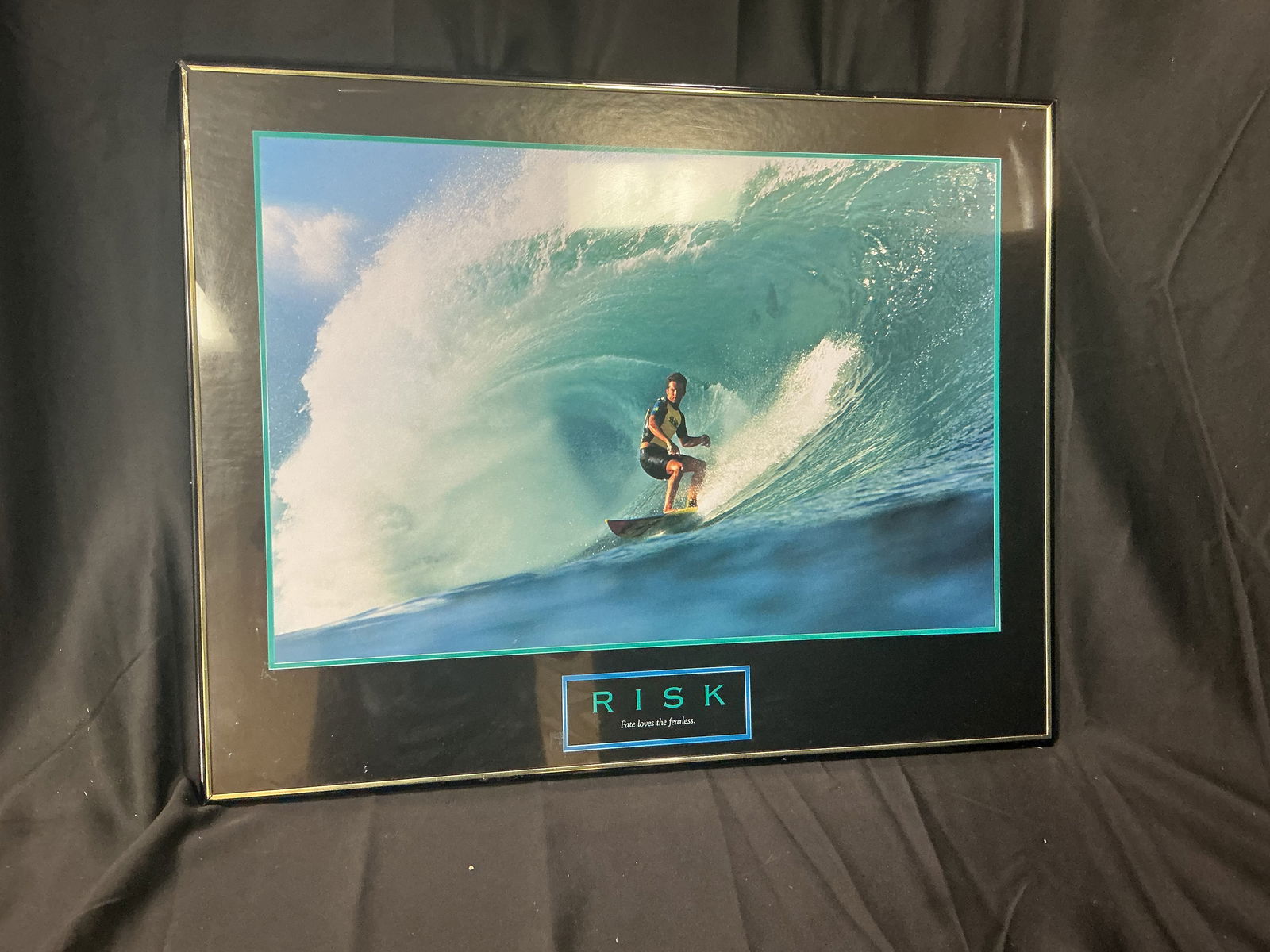 Risk Motivational Poster Big Wave Surfer in Barrel (Successories-style): High-energy photograph of a surfer riding inside a massive curling turquoise wave. Bold lettering reads RISK with the caption Fate loves the fearless. Classic late-1990s/early-2000s corporate