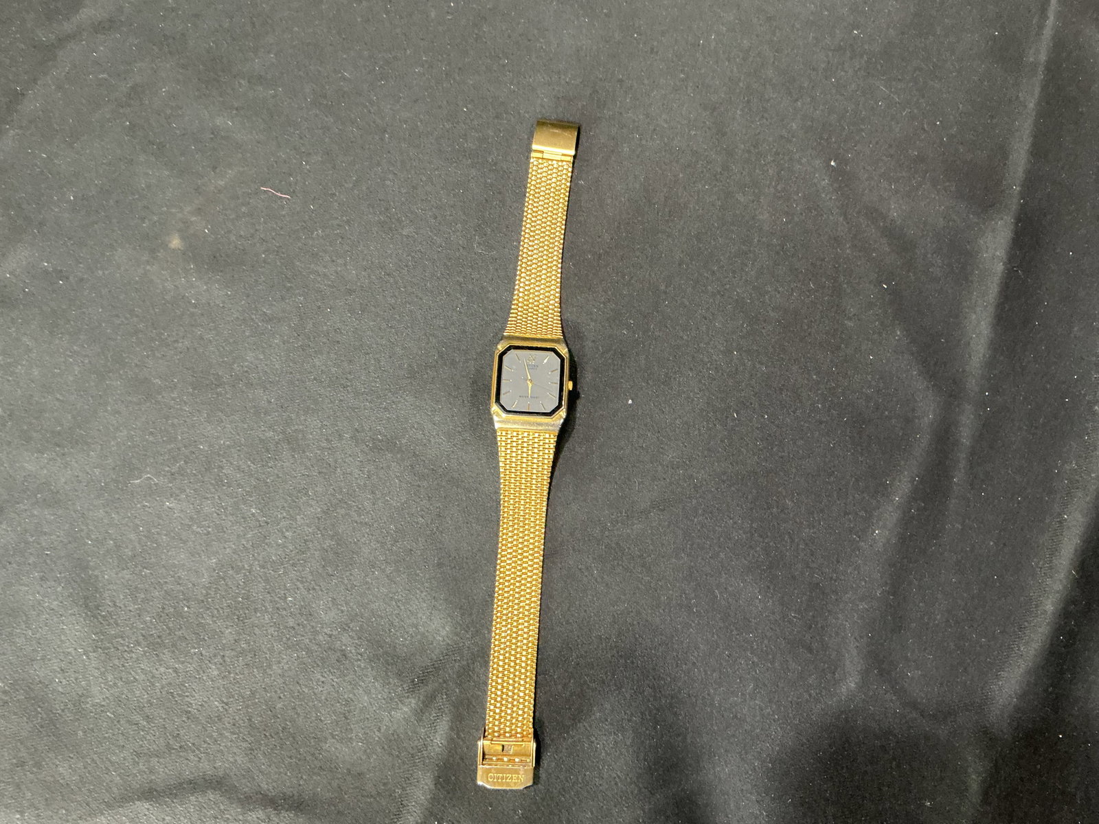 Citizen Gold-Tone Quartz Wristwatch with Mesh Bracelet: Vintage Citizen quartz wristwatch featuring a gold-tone rectangular case with a black bezel and a gray dial with gold-tone baton hour markers and hands. The watch is fitted with a matching gold-tone m