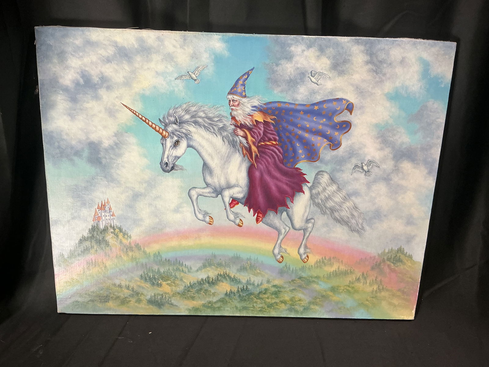 Fantasy Wizard Riding Unicorn Rainbow Landscape Oil Painting on Canvas: Fantasy themed oil painting depicting a wizard in flowing robes riding a unicorn above a rainbow landscape with distant castle and birds in the sky. Bright colors and detailed illustration create a wh