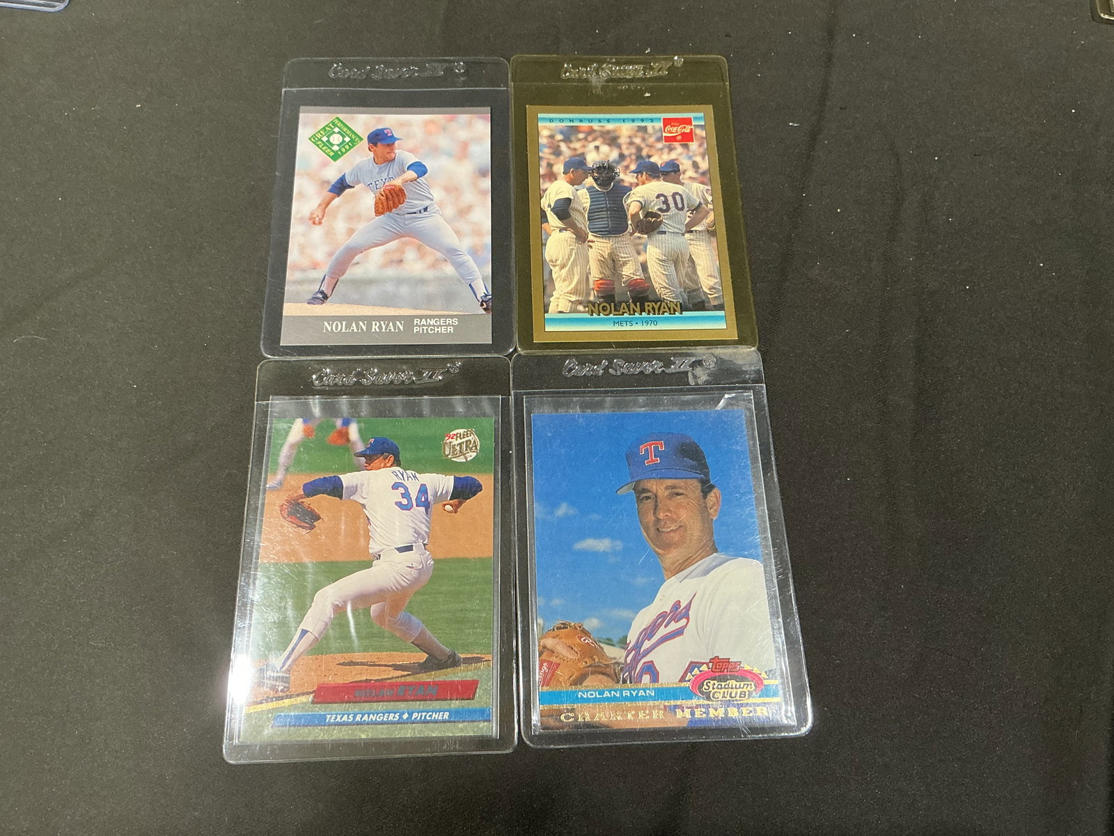 Nolan Ryan Baseball Card Group of 4 Rangers Mets Mixed Issues: Group of four vintage and modern Nolan Ryan baseball cards including Texas Rangers and New York Mets issues. Includes Upper Deck, Fleer, Donruss Coca-Cola issue, and Topps Stadium Club insert commemor