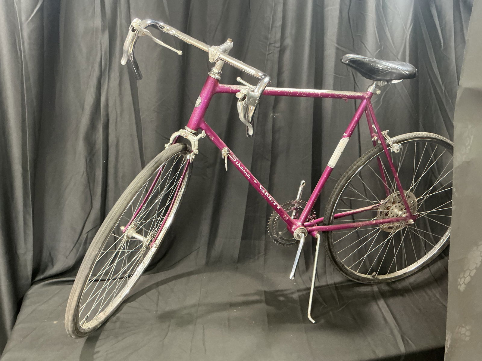 1970s Schwinn Varsity 10-Speed Road Bicycle - Magenta: Vintage Schwinn Varsity 10-speed road bicycle in magenta; includes drop handlebars, steel frame, Schwinn components; heavy wear, oxidation, rust, scratches, and missing grips; SN: GC01060; sold as-is.