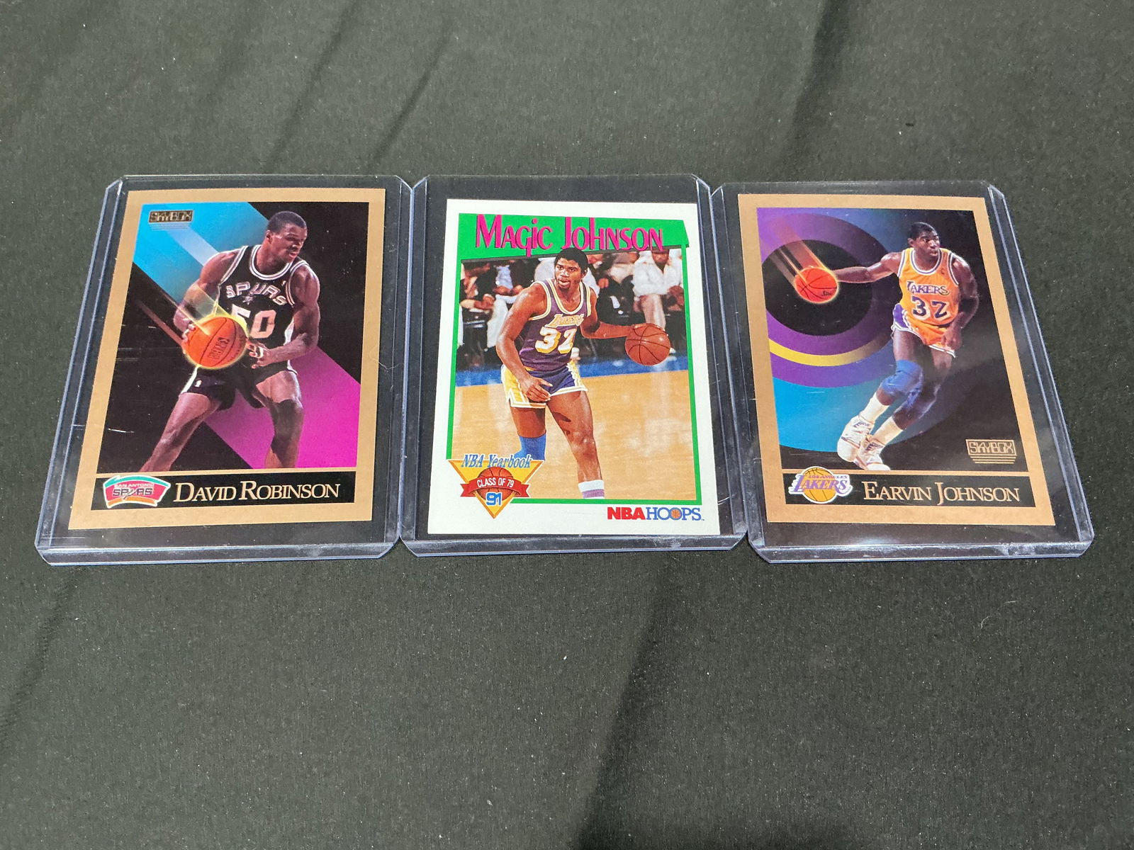 1990 SkyBox David Robinson and Magic Johnson Basketball Cards (3): Group of three 1990 SkyBox NBA basketball cards including David Robinson (San Antonio Spurs) and two Magic Johnson (Los Angeles Lakers) cards. Features colorful early-1990s SkyBox design with player s