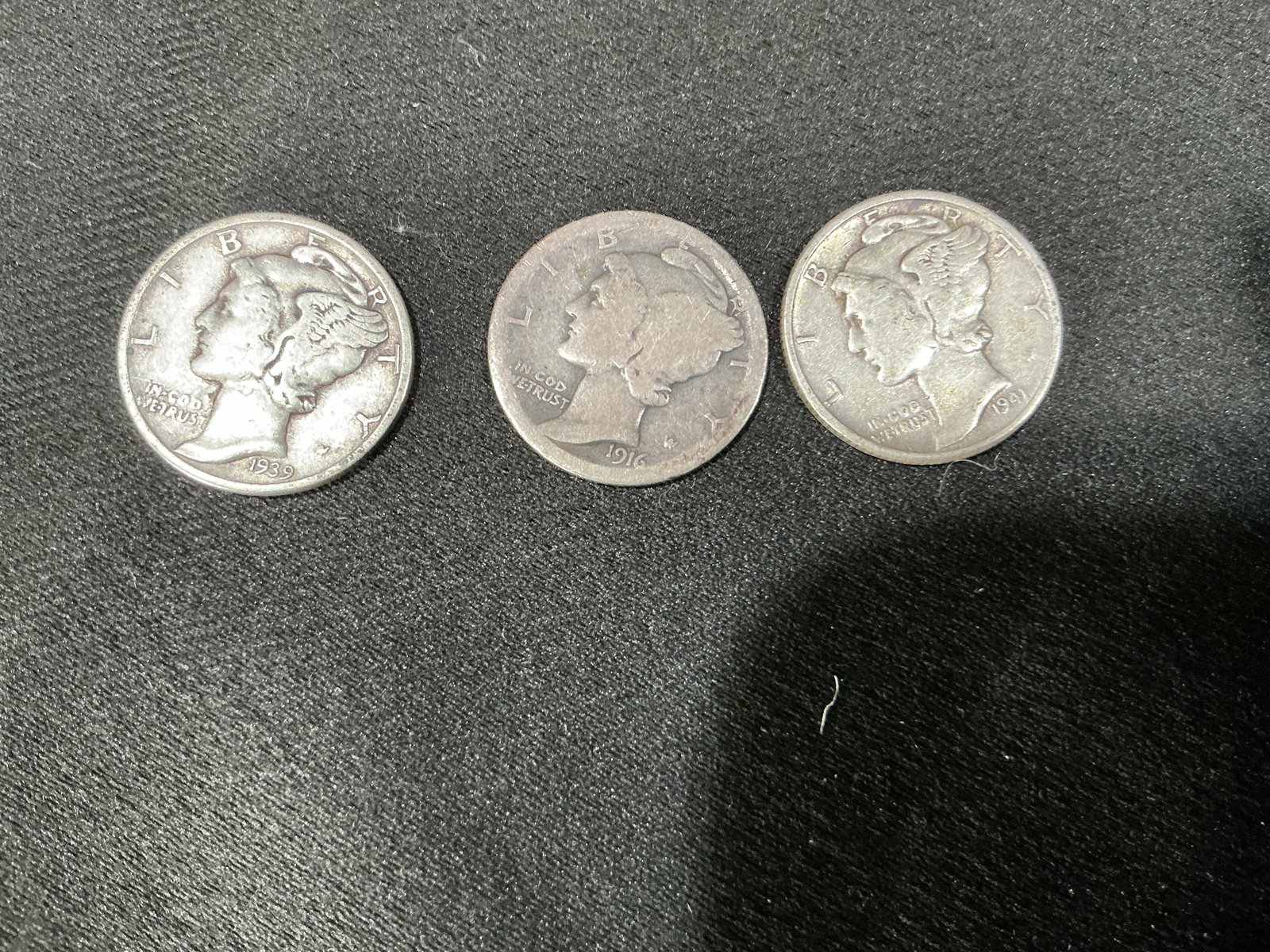 Three Mercury Dimes 1916 1941 1939 Silver Coins: Group of three vintage United States Mercury dimes dated 1916, 1941, and 1939. Classic Winged Liberty Head design. All coins show circulated wear with visible dates and details. A nice collectible sil