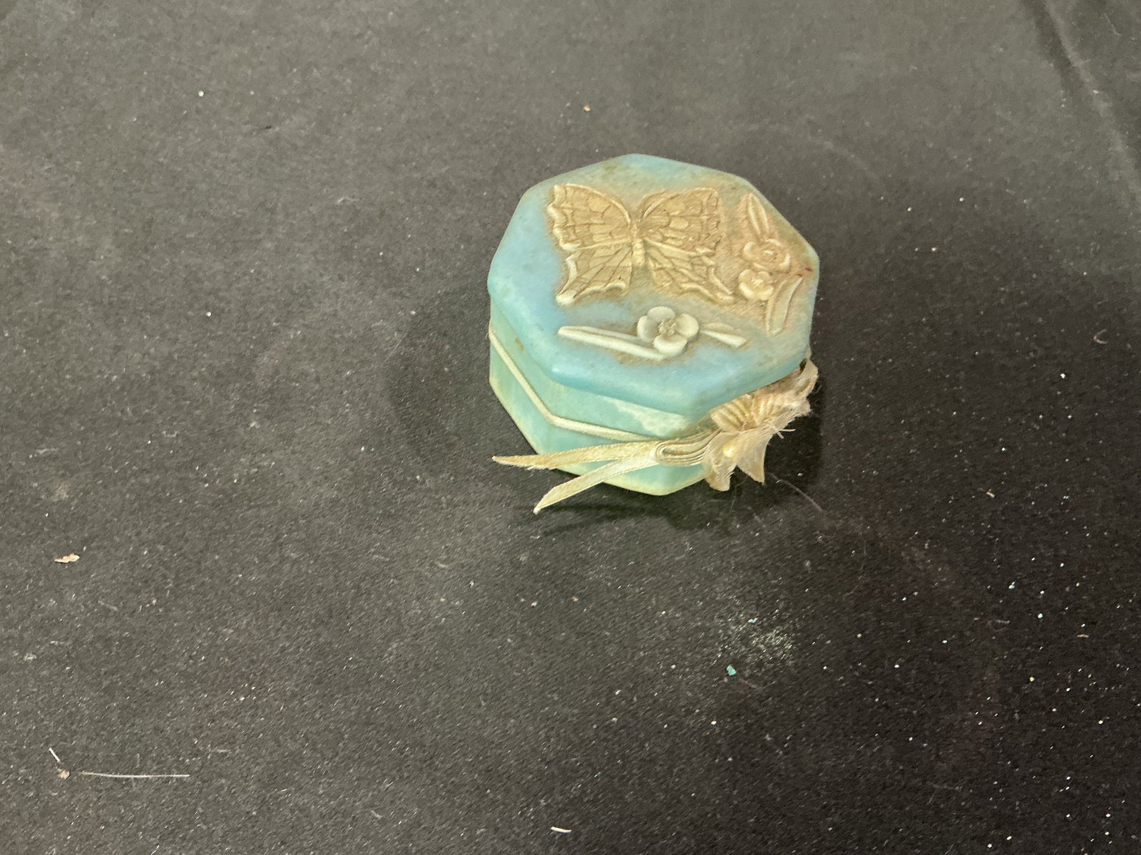 Vintage Blue Jasperware Style Trinket Box Butterfly Motif: Vintage blue jasperware style trinket box with applied butterfly and floral relief decoration. Octagonal form with fitted lid and decorative ribbon accent. Suitable for jewelry or small keepsakes.