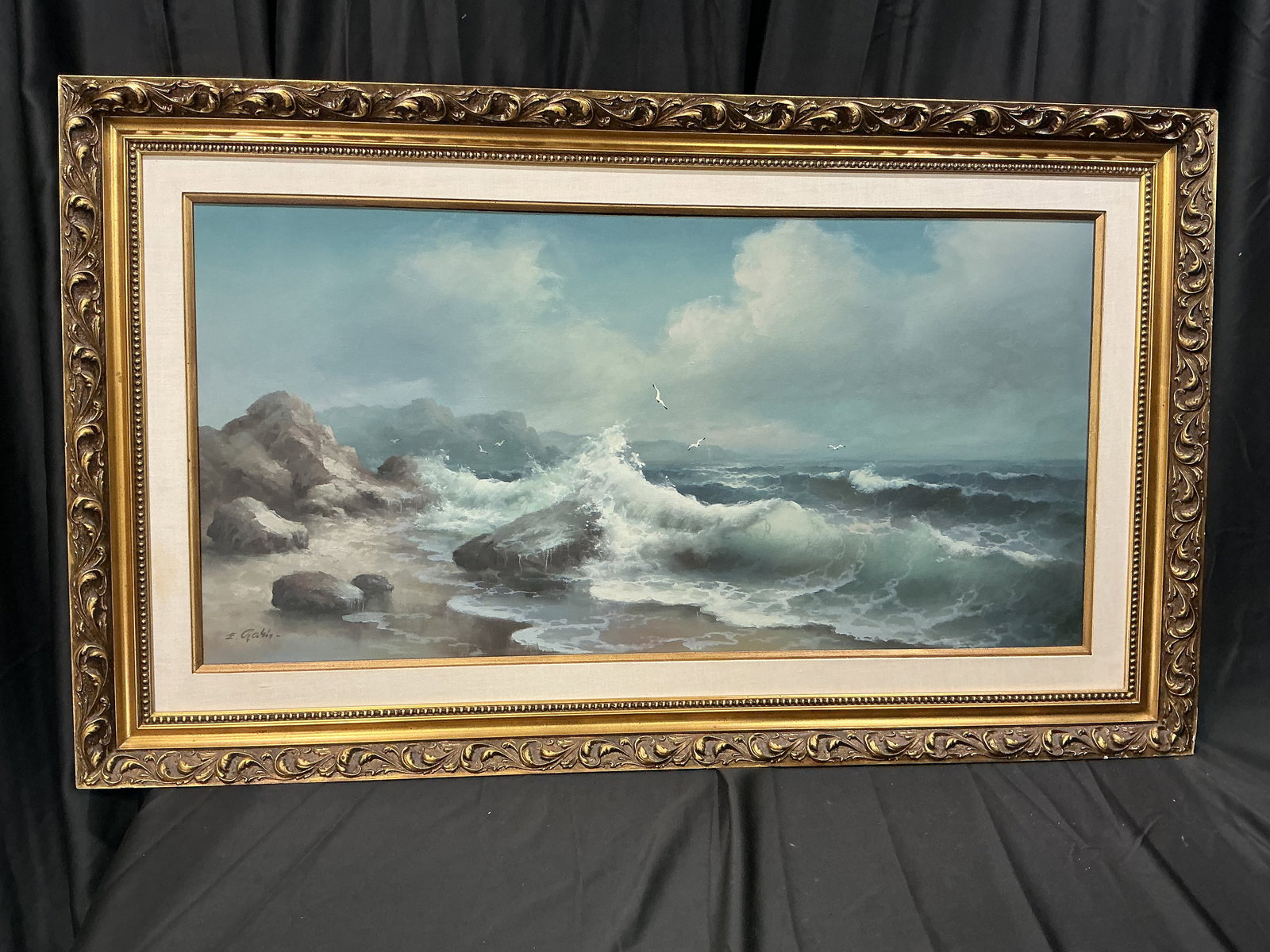 Signed Coastal Seascape Oil Painting Waves Crashing Ornate Gold Frame: Framed seascape painting depicting waves crashing along a rocky shoreline with seabirds overhead. Signed lower left (appears E. Garin). Presented in an ornate gold-tone frame.