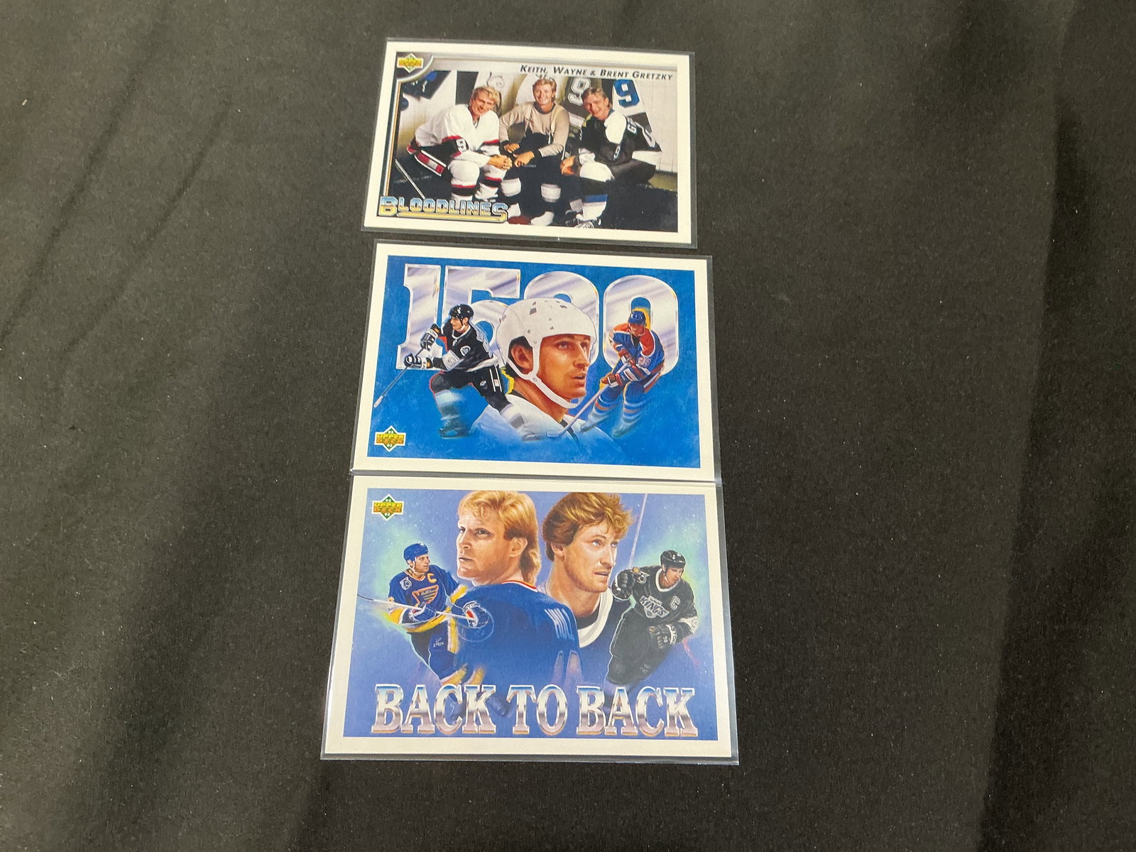 Wayne Gretzky NHL Insert Card Collector Group: Group of three Upper Deck Wayne Gretzky themed hockey insert cards including Gretzky 1500, Back to Back, and Keith Wayne and Brent Gretzky Bloodlines insert. Features iconic imagery and milestone them