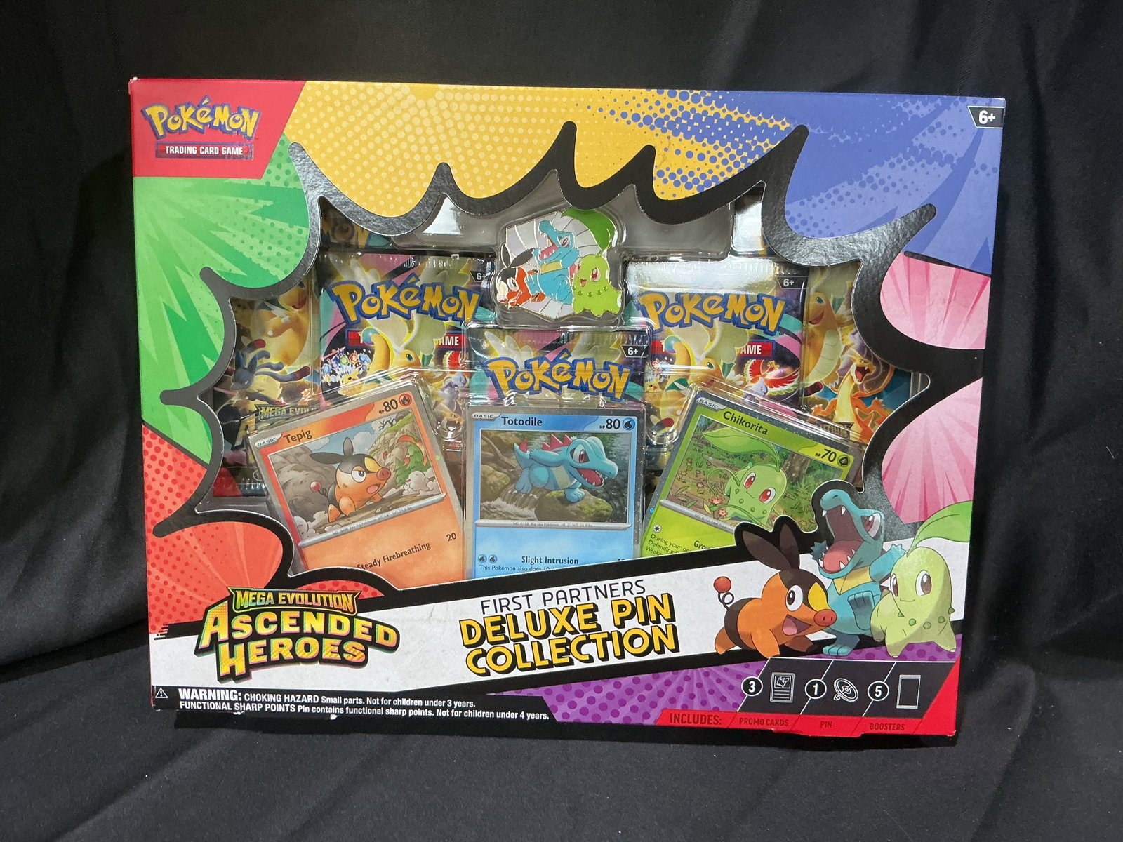 Pokemon First Partners Deluxe Pin Collection Box Sealed: Factory sealed Pokemon Mega Evolution Ascended Heroes First Partners Deluxe Pin Collection featuring Chikorita, Tepig, and Totodile promo cards with matching enamel pin and five booster packs. Colorfu