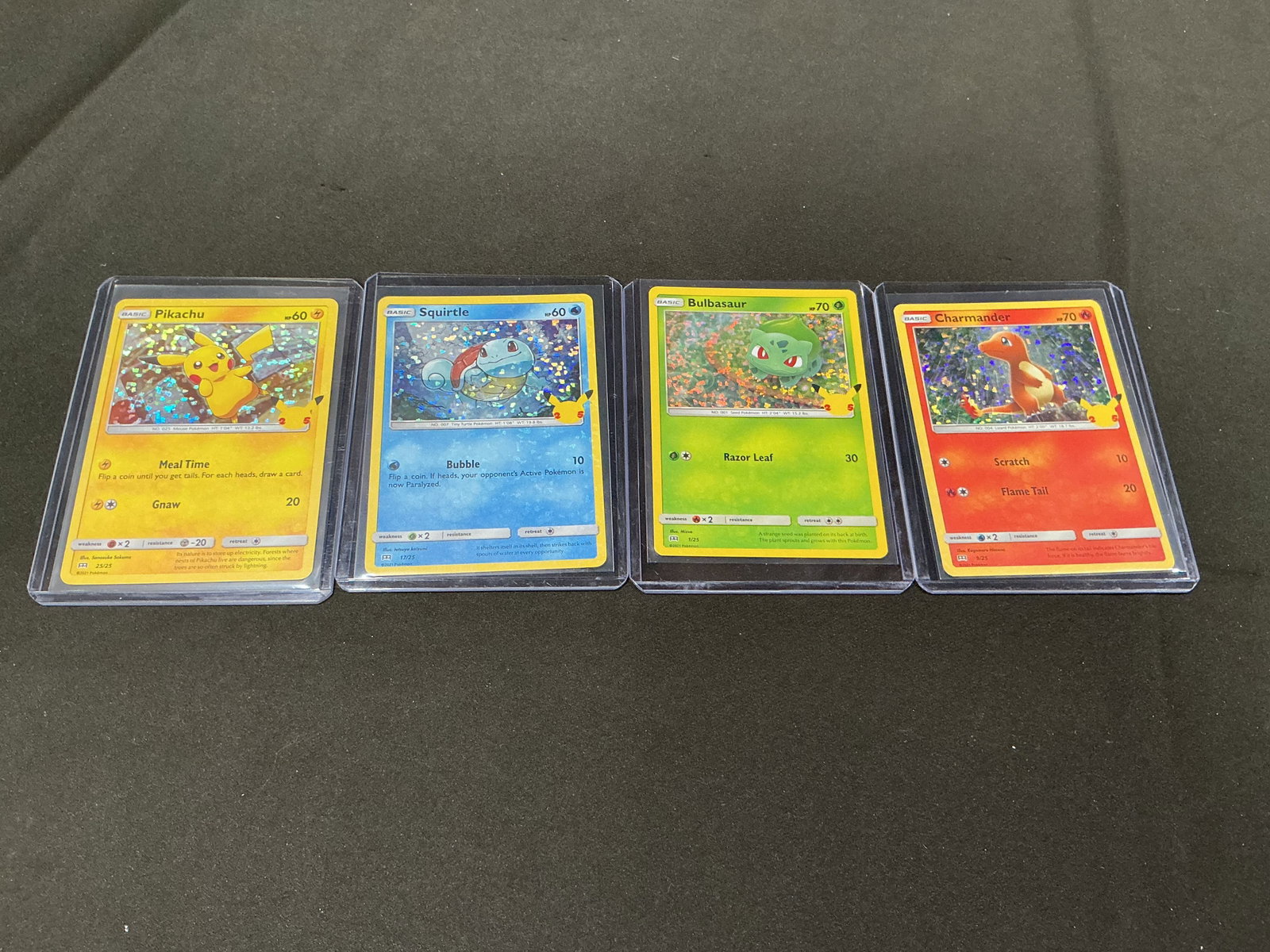 Pokemon 25th Anniversary Starter Holo Card Lot Pikachu Squirtle Bonus Offering: Pokemon 25th Anniversary holographic starter card lot featuring Pikachu, Squirtle, Bulbasaur, and Charmander. Classic Kanto lineup with anniversary Pikachu stamp logos and colorful holo foil