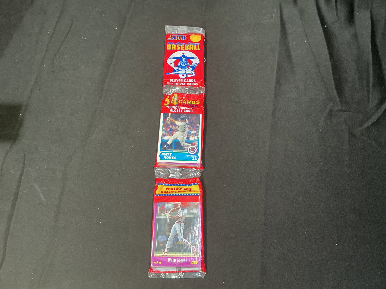 1990 Score Baseball Wax Pack Matt Nokes Willie McGee: Vintage sealed 1990 Score Baseball wax pack featuring Matt Nokes and Willie McGee on the wrapper panels. Includes 54 cards plus bonus young superstar glossy card. Popular early 1990s baseball release