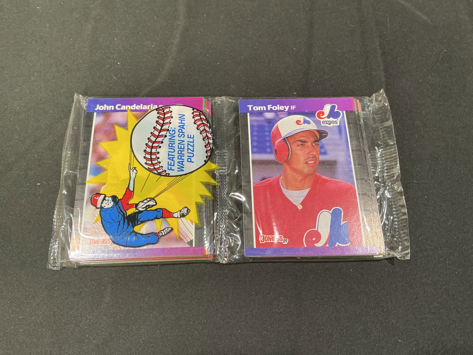 1989 Donruss Baseball Wax Pack Warren Spahn Puzzle Tom Foley John Candelaria: Vintage 1989 Donruss Baseball wax pack featuring visible Tom Foley and John Candelaria cards with Warren Spahn puzzle insert promotion. Unopened baseball trading card pack with classic late 1980s coll