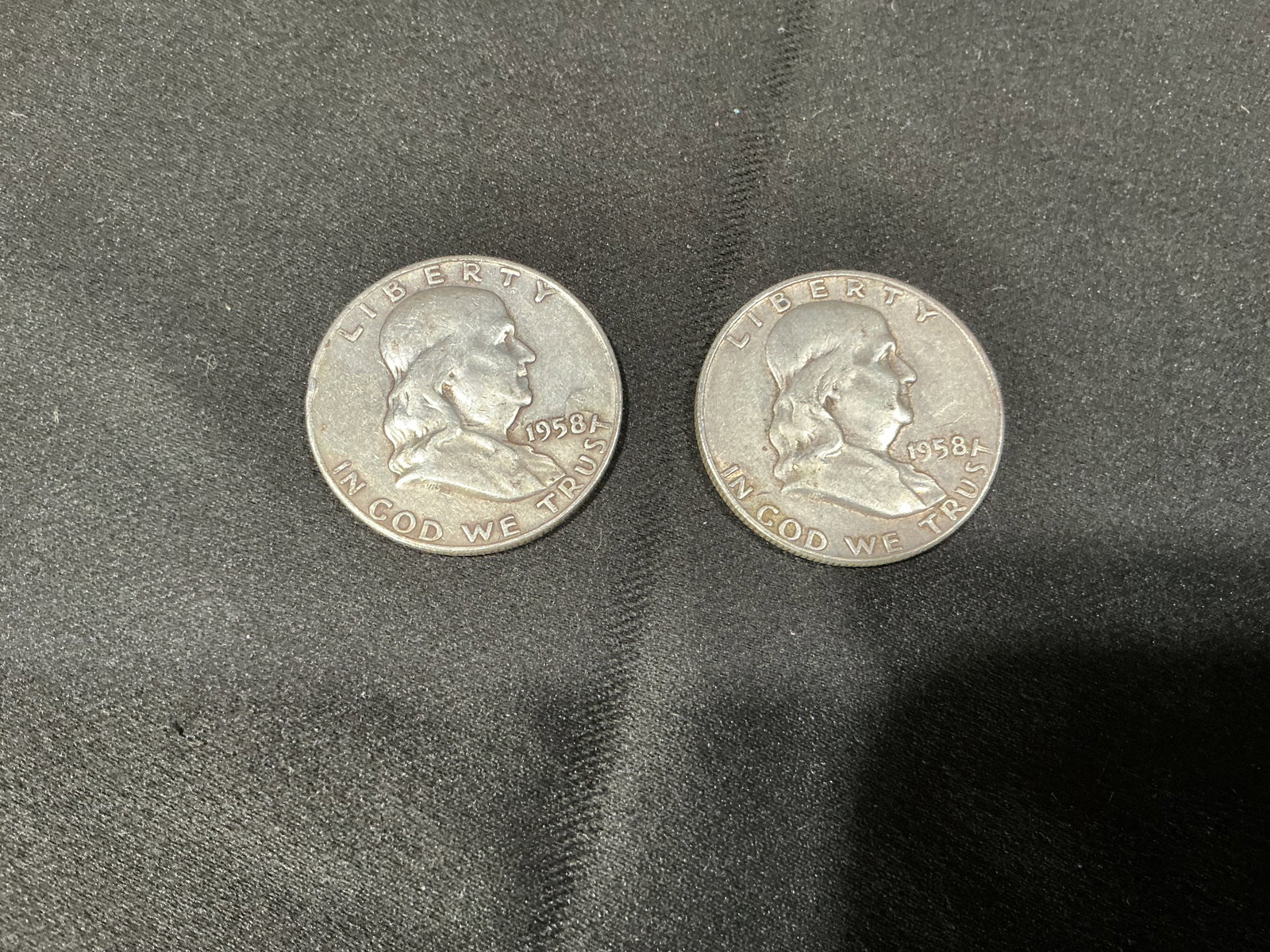 1958 Franklin Silver Half Dollar Coin Pair: Pair of 1958 Benjamin Franklin half dollar coins featuring Liberty Bell reverse design. Includes two matching vintage U.S. silver half dollars as shown.