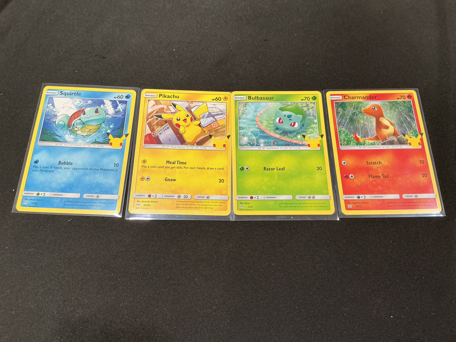 Pokemon 25th Anniversary Kanto Starter Card Lot Returning Favorite Final Series Offering: Pokemon 25th Anniversary card lot featuring Pikachu, Squirtle, Bulbasaur, and Charmander cards. Classic Kanto starter lineup with strong nostalgia appeal for Pokemon collectors and anniversary set