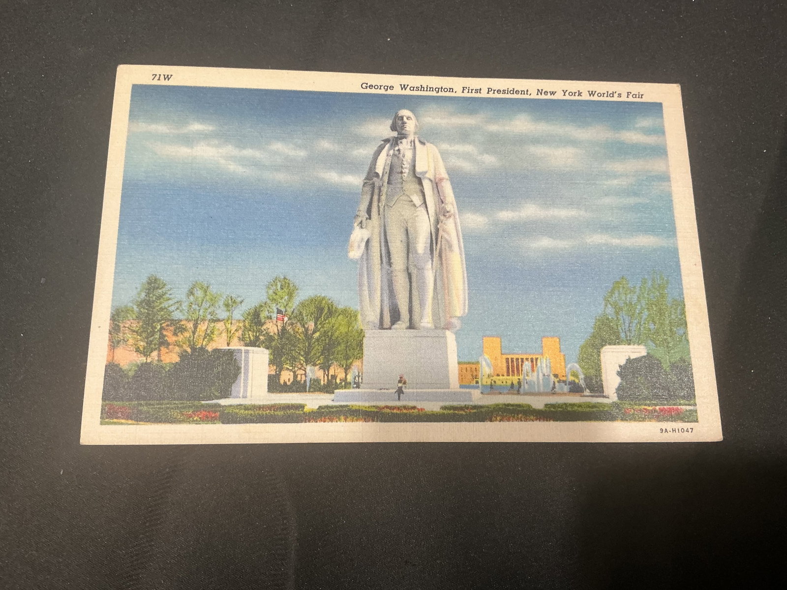 1939 New York World's Fair George Washington Postcard: Vintage officially licensed 1939 New York World's Fair postcard featuring the George Washington statue and Constitution Mall display. Reverse includes historical information regarding the monumental