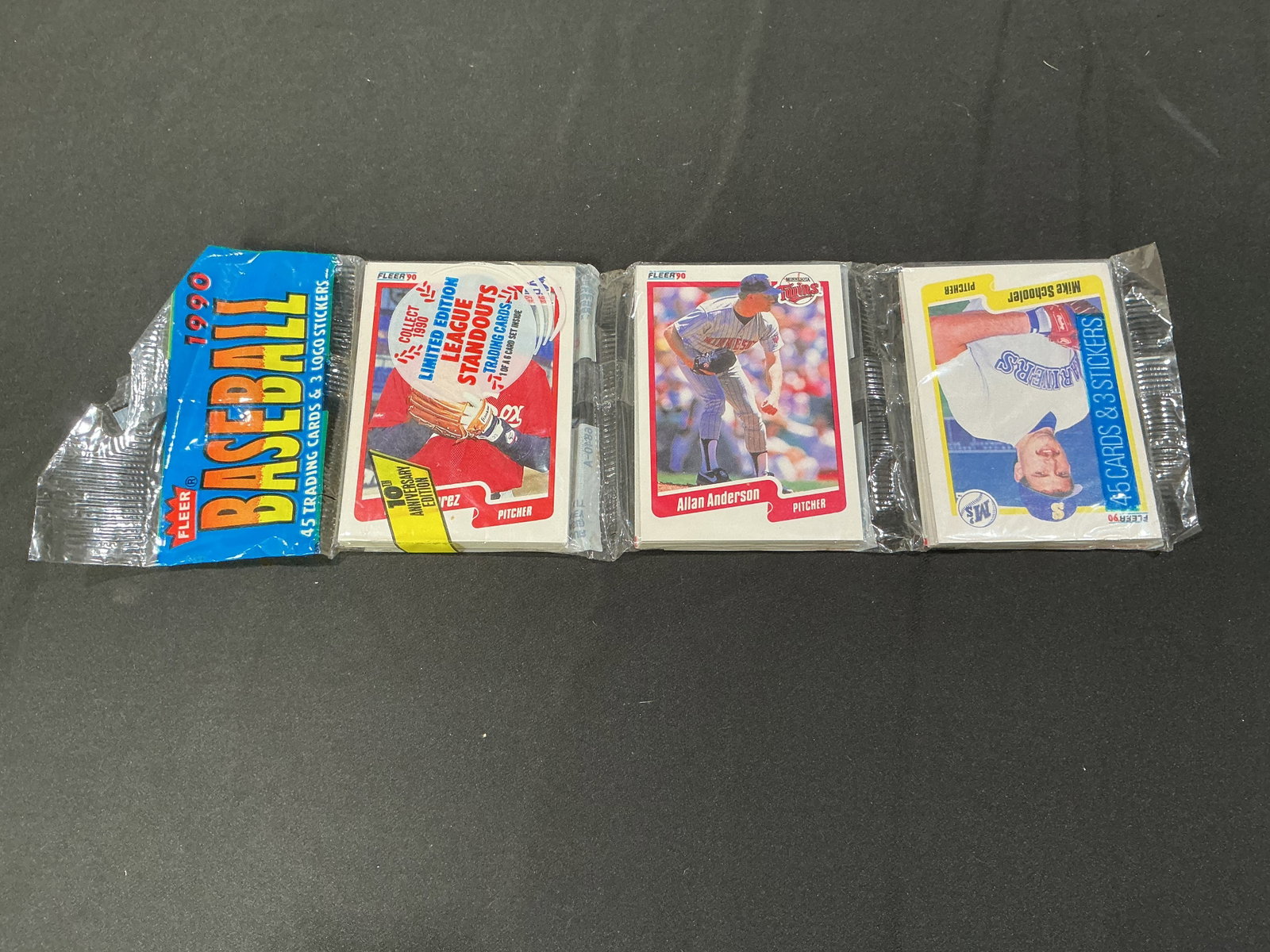 1990 Fleer Baseball Wax Pack Sealed Trading Cards featuring Allen Anderson: Sealed 1990 Fleer Baseball wax pack containing trading cards and logo stickers from the classic Fleer release. Features vintage MLB-era packaging with potential stars, rookies, and insert content