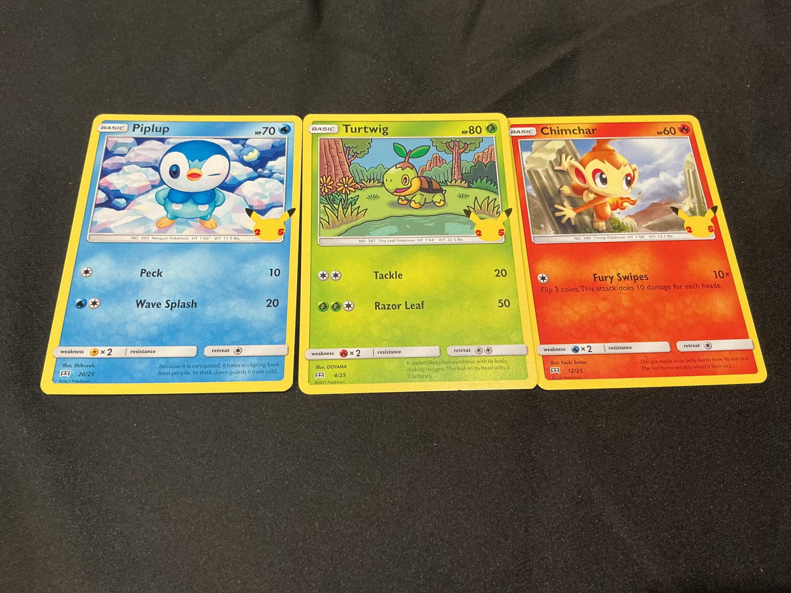 Pokemon 25th Anniversary Piplup Turtwig Chimchar Card Trio: Pokemon 25th Anniversary starter trio featuring Piplup, Turtwig, and Chimchar cards with bright anniversary-era presentation and Sinnoh starter appeal. This returning Pokemon card grouping has run