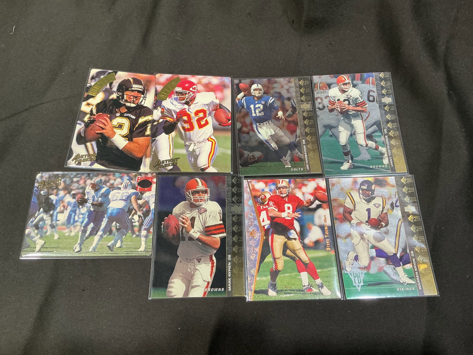 1990s NFL Quarterback & Star Player Card Lot Harbaugh Moon Rypien Young: Group of vintage 1990s football cards featuring notable NFL quarterbacks and stars including Jim Harbaugh, Warren Moon, Mark Rypien, Steve Young, Vinny Testaverde, and Christian Okoye. Includes Action