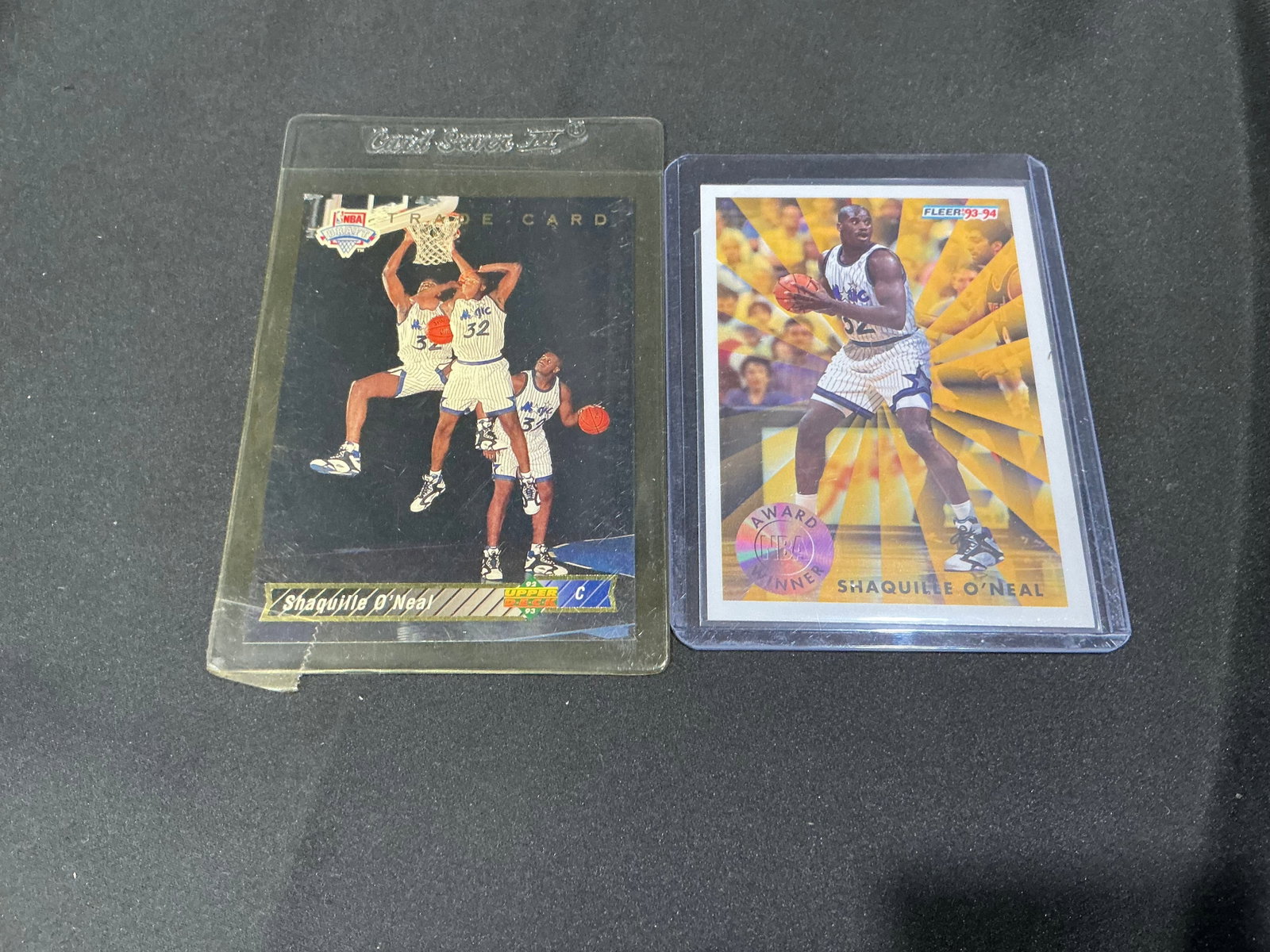 Shaquille O'Neal Card Pair Rookie Era: Two-card Shaquille O'Neal lot featuring a 1993 Upper Deck trade card and 1993-94 Fleer Award Winner Rookie of the Year card. Nice NBA Hall of Fame player grouping with strong appeal for basketball