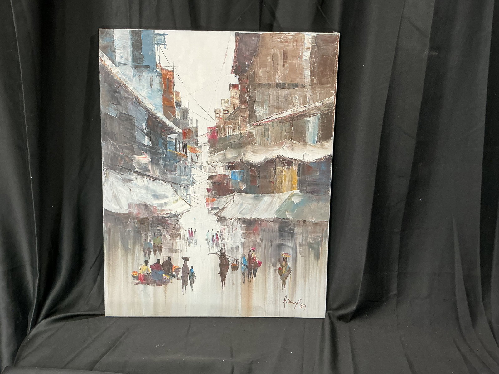 Signed 1989 Street Market Oil Painting: Original signed 1989 oil painting depicting a bustling street market scene with figures, vendor stalls, and atmospheric urban architecture. Unframed canvas on stretcher with decorative display