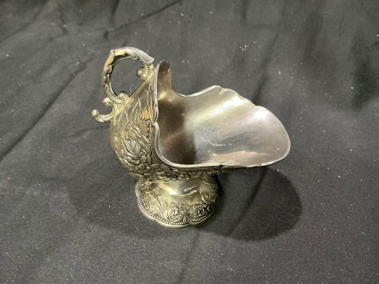 Ornate Silverplate Floral Creamer: Returning after several weeks away. Decorative silverplate creamer featuring detailed floral repousse body, ornate scroll handle, footed base, and engraved border. Classic Victorian style display