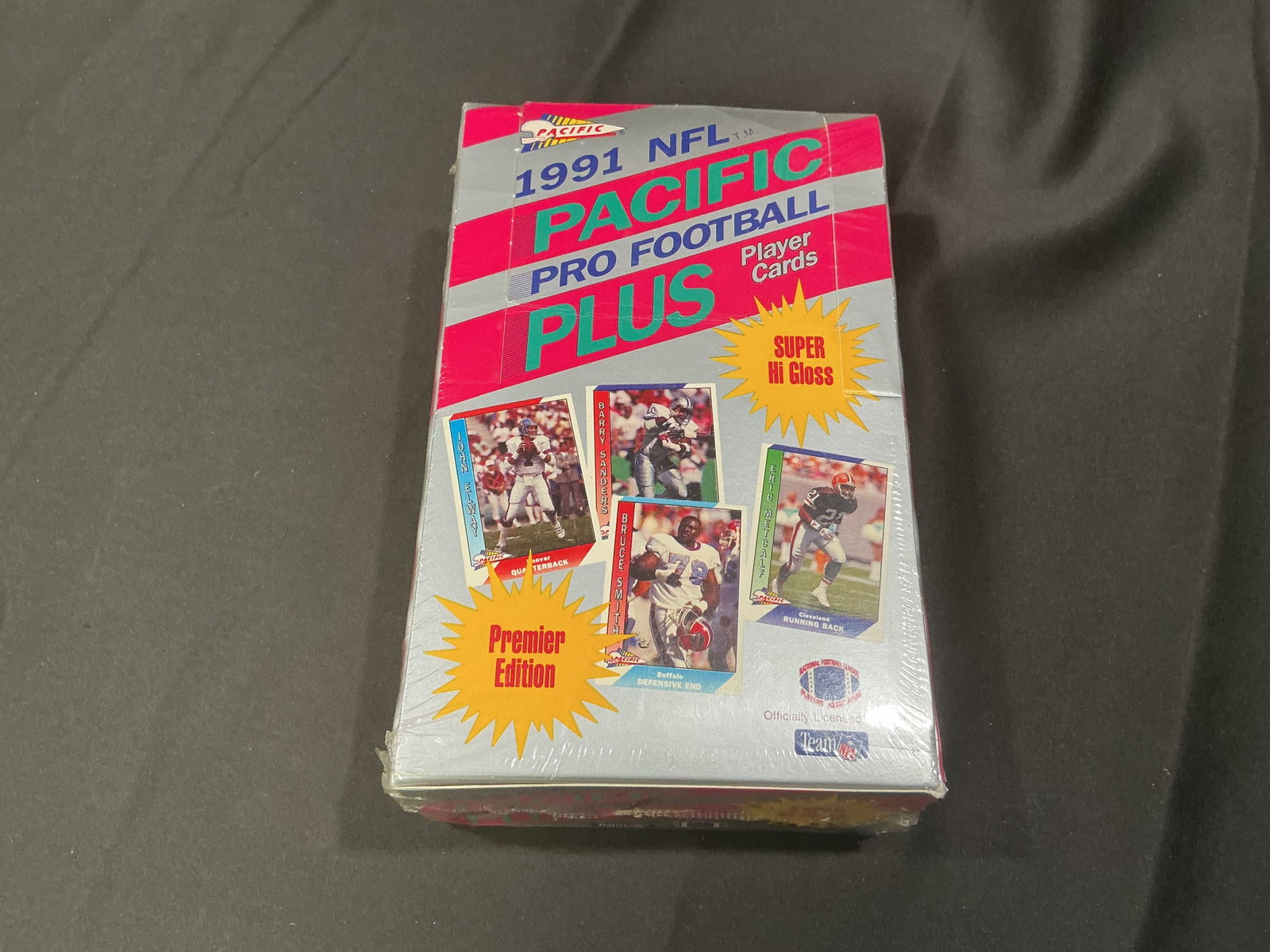 1991 Pacific Plus NFL Wax Box: 1991 Pacific Plus NFL Football Premier Edition sealed wax box featuring the glossy early-90s football style that separates it from more common releases. A solid football collector lot with visual